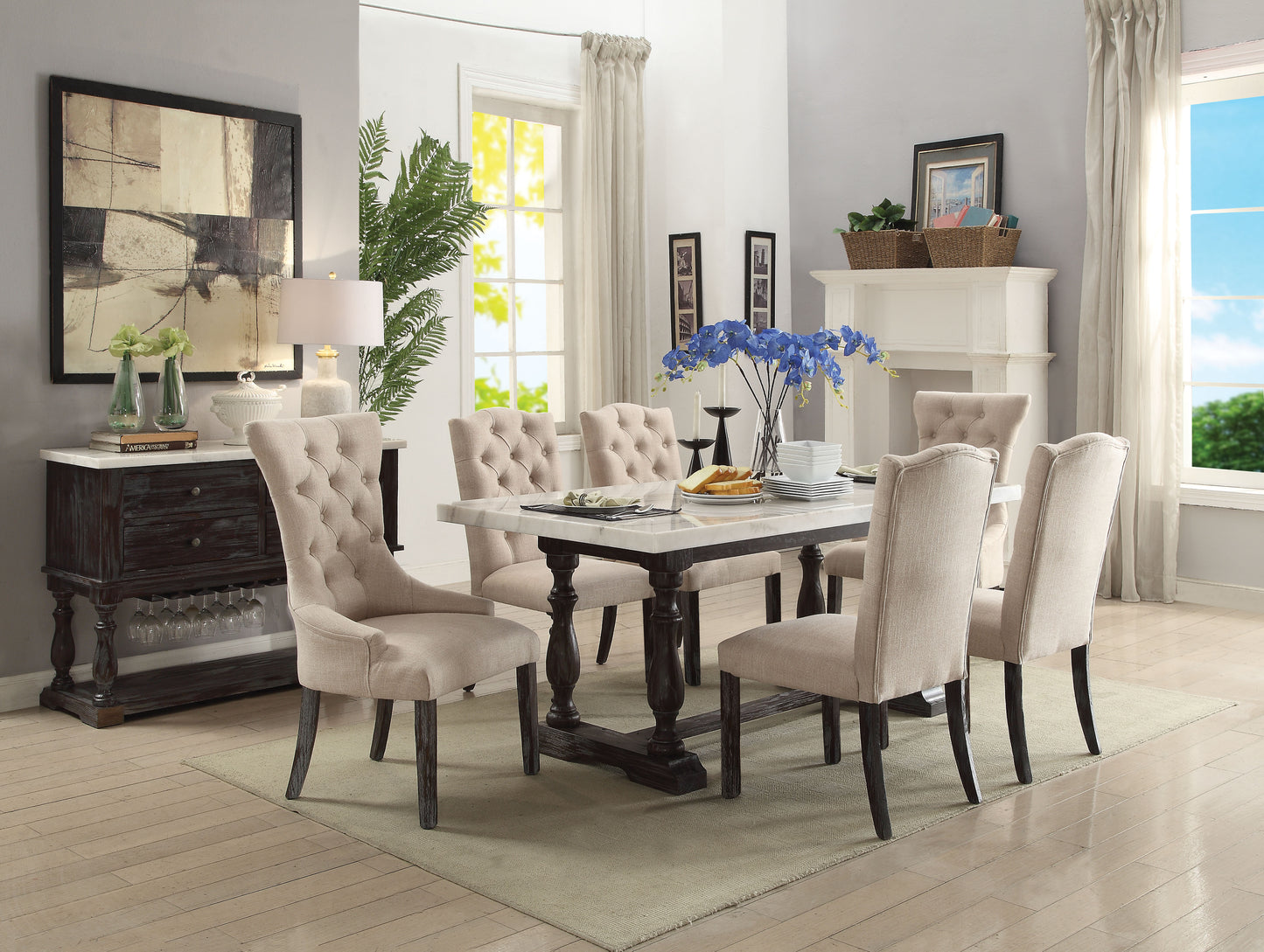 Tufted beige dining chairs surrounding a marbletop dining table with dark wood base