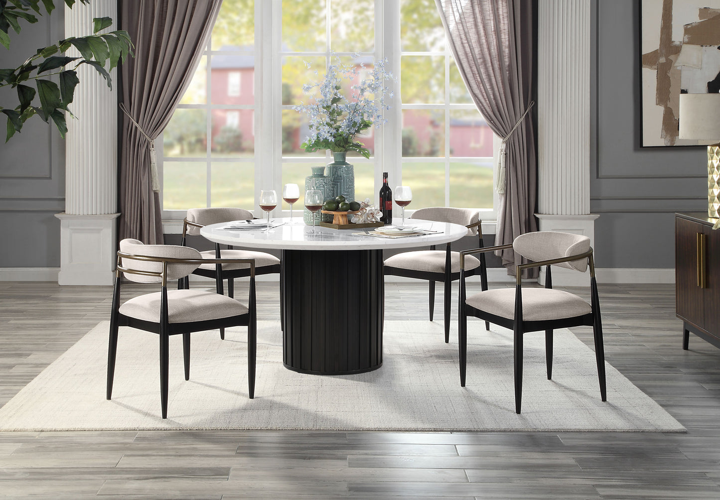 Round marble dining table with fluted black pedestal base and four upholstered chairs