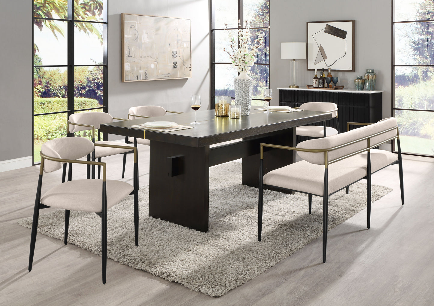 Dark wood modern dining table with upholstered cream chairs and gold accents