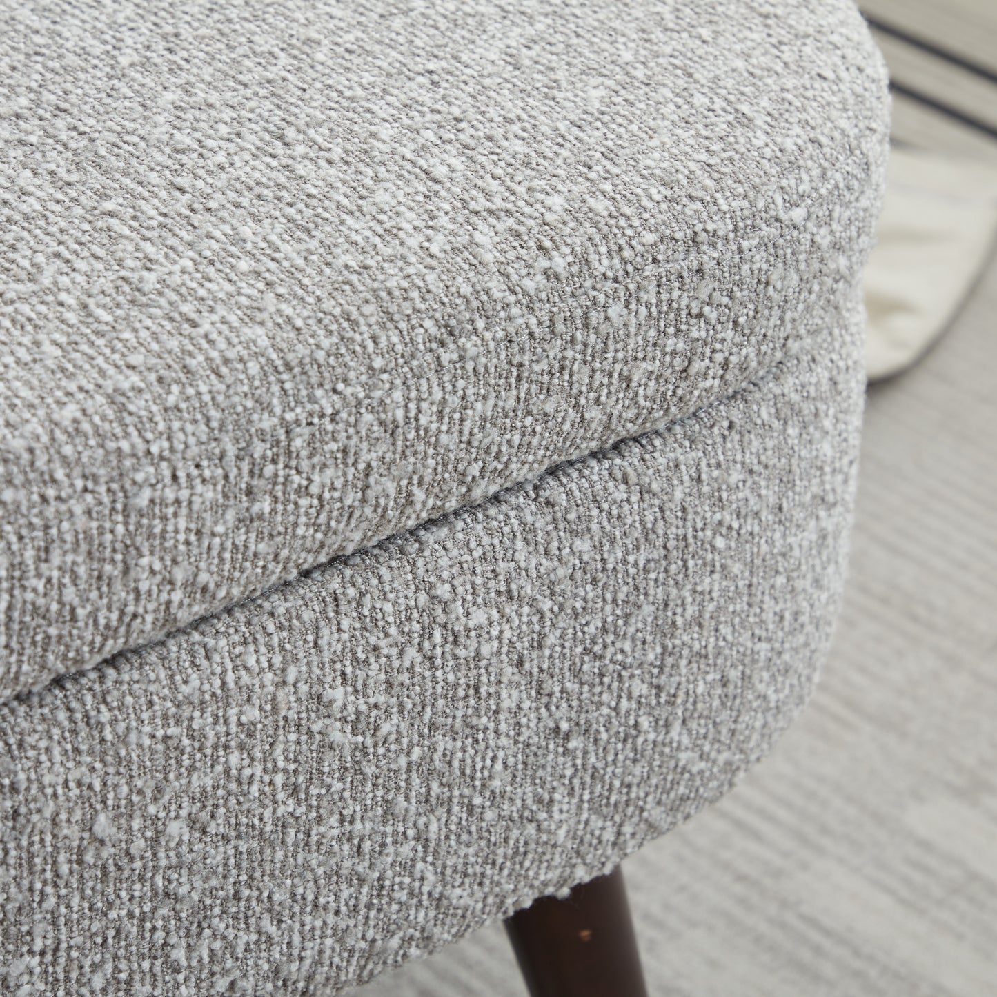 Closeup of textured grey fabric on a modern ottoman showing the woven detail
