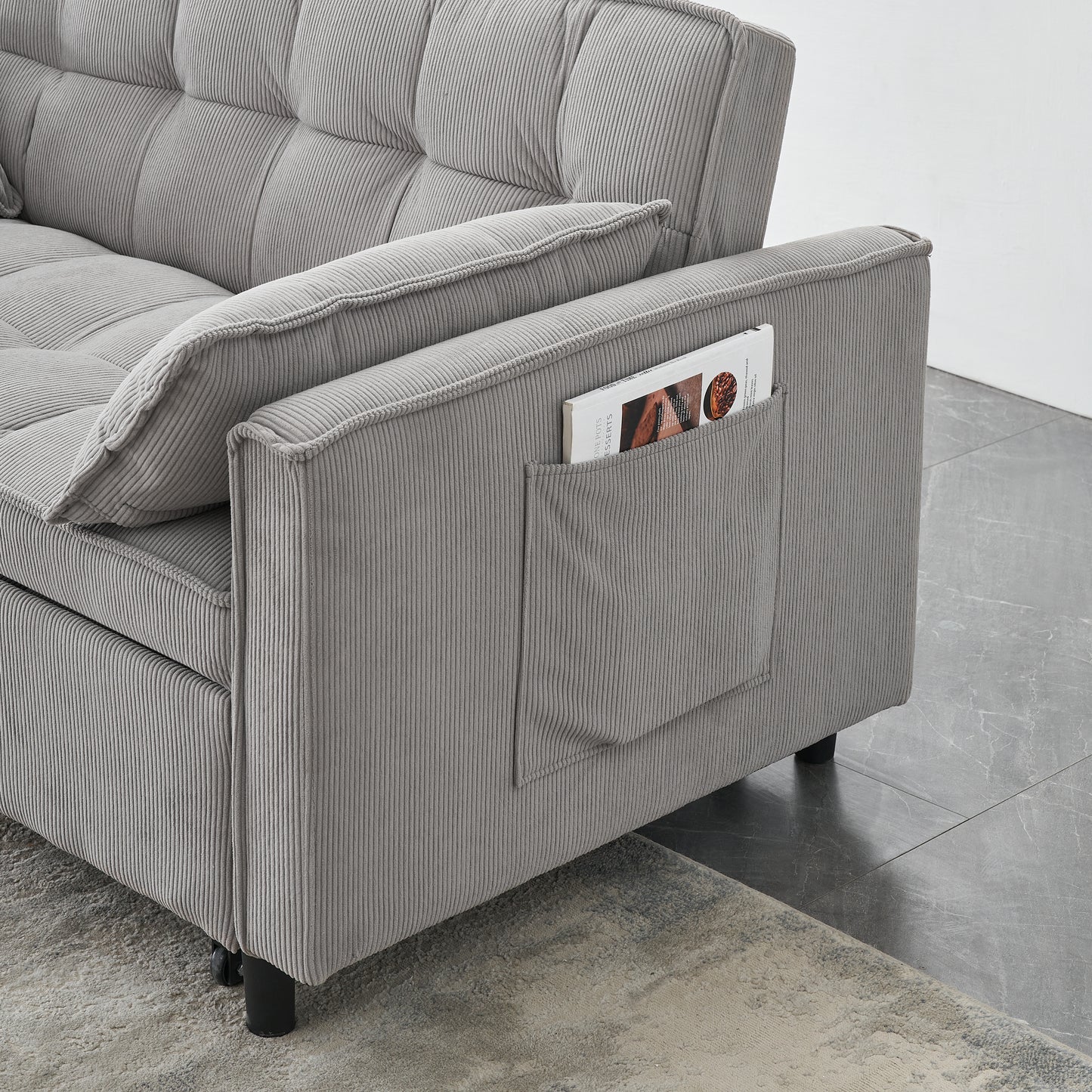 Close up of grey corduroy sofa arm with a convenient side pocket holding a magazine