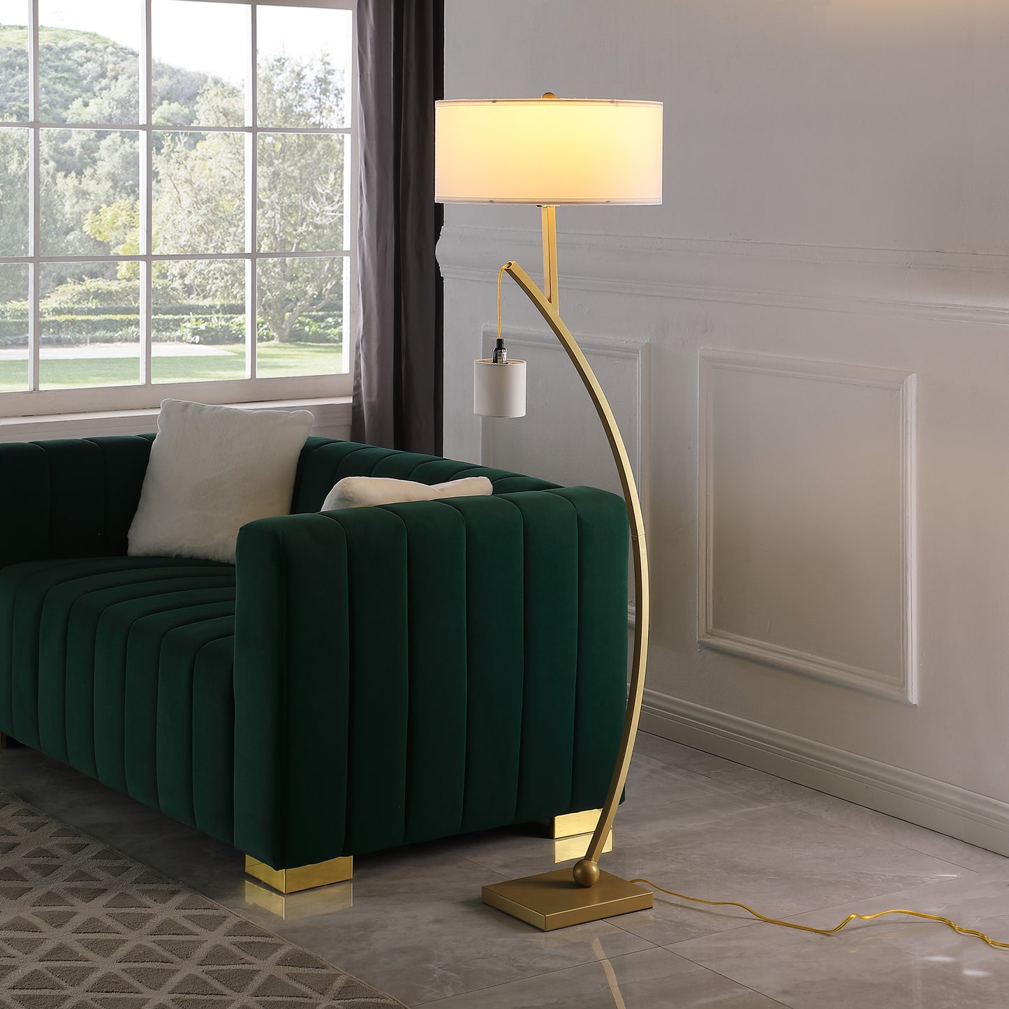 Arcing gold floor lamp with white drum shade and integrated task light