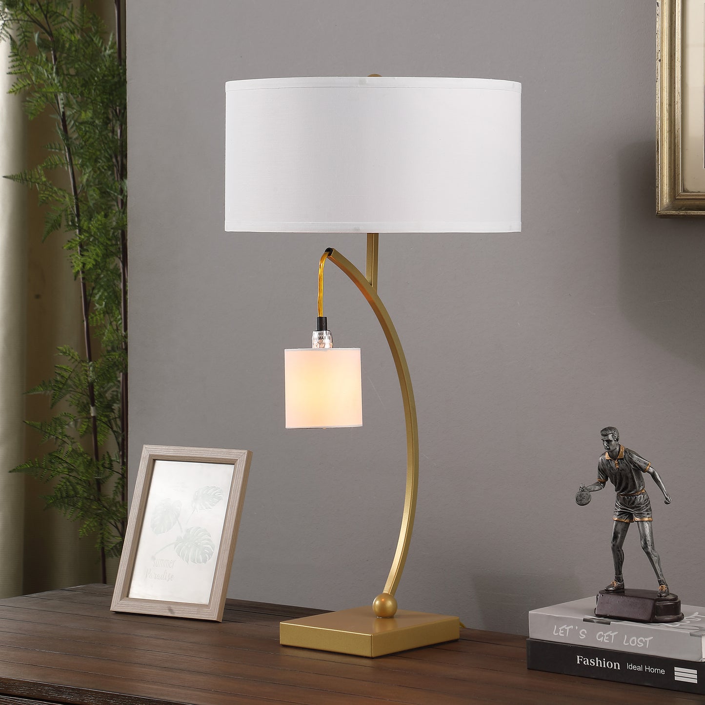 Gold curved desk lamp with white drum shade and decorative square pendant light