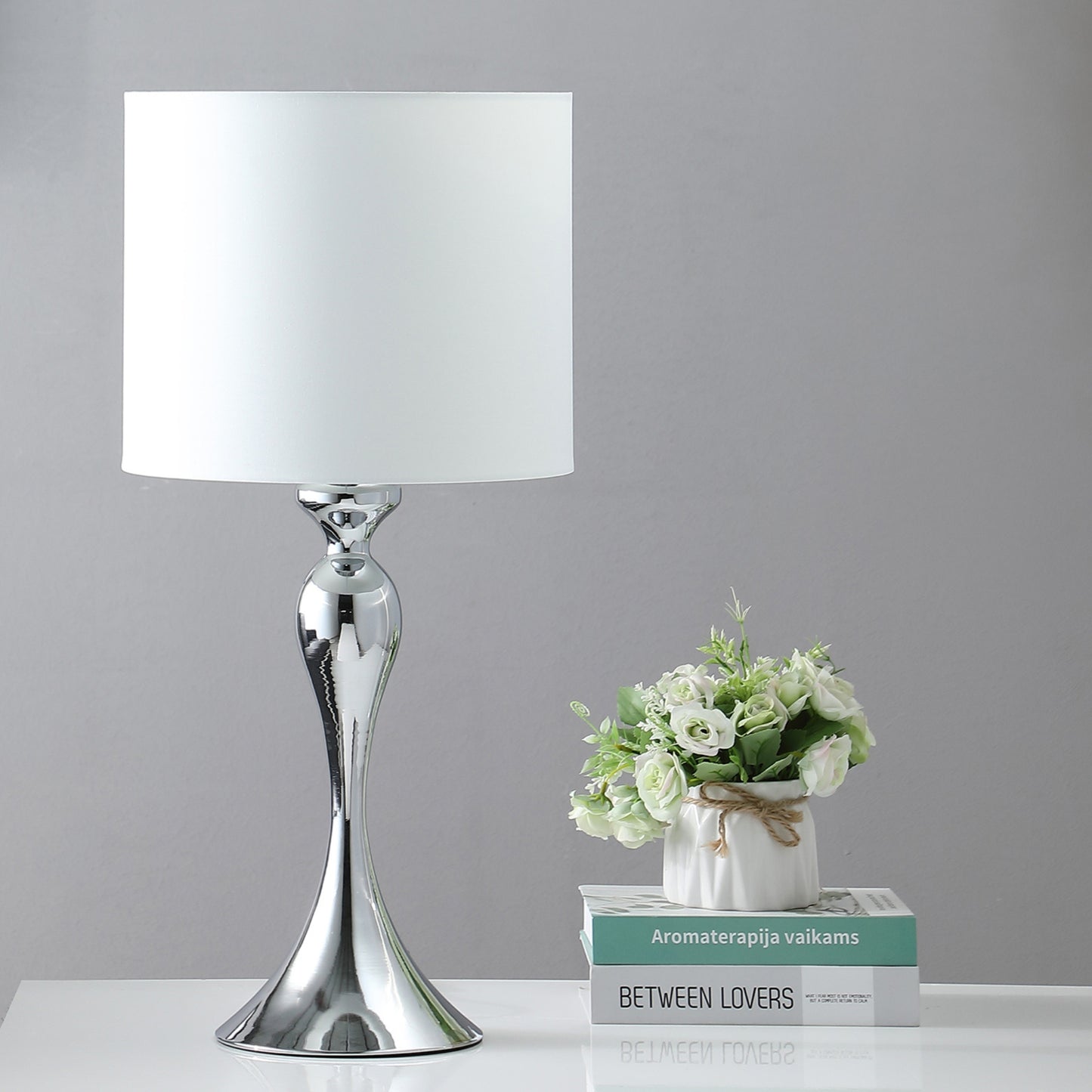 Sleek chrome table lamp with a white drum shade ideal for modern living spaces