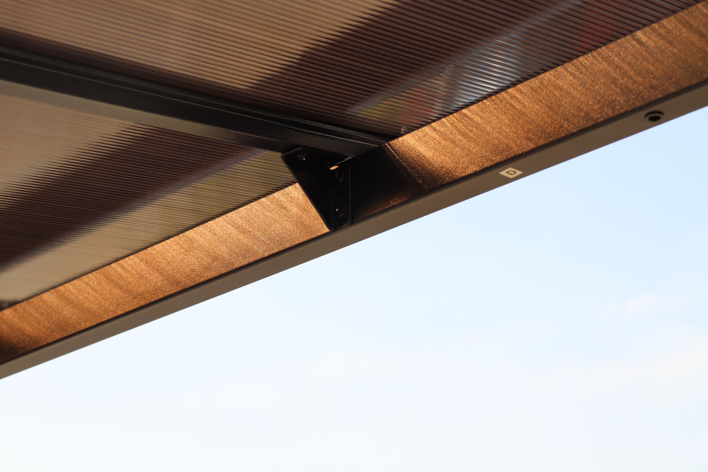 Polycarbonate canopy roof with bronze aluminum frame providing shade