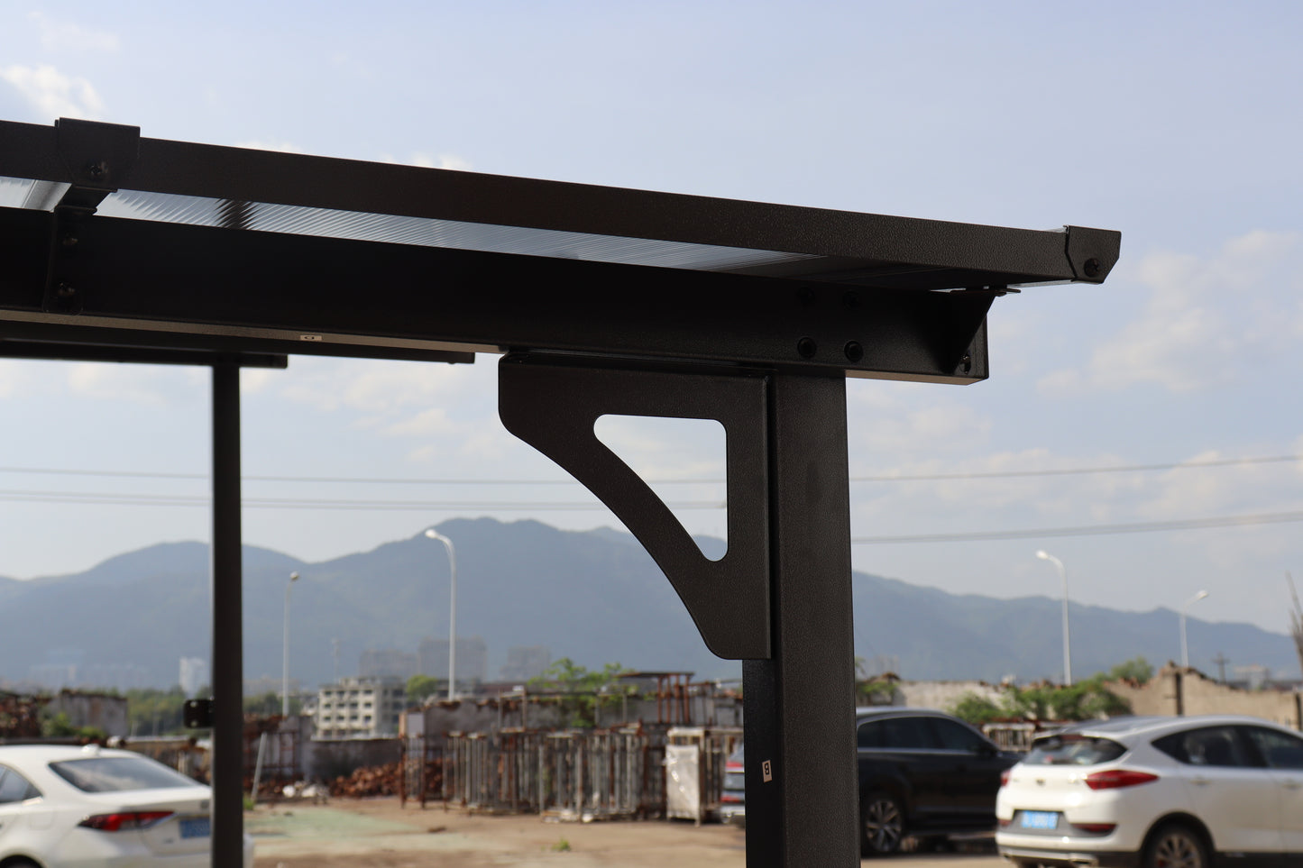 Black metal carport frame with clear polycarbonate roofing detail
