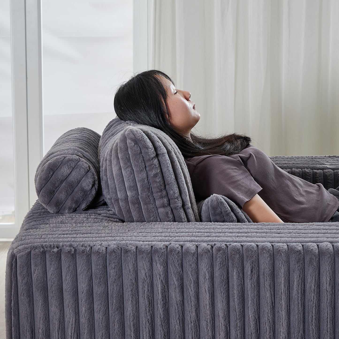 Plush grey corduroy couch featuring plush armrest pillows and comfortable seating