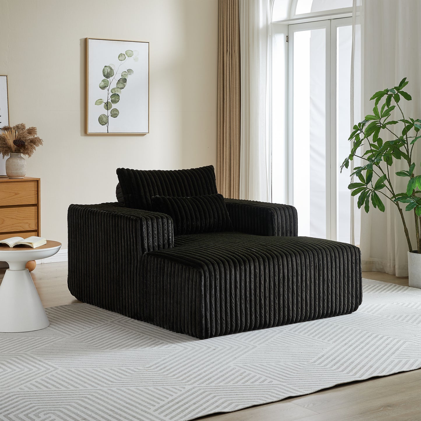 Black corduroy chaise lounge chair with plush pillows and modern design