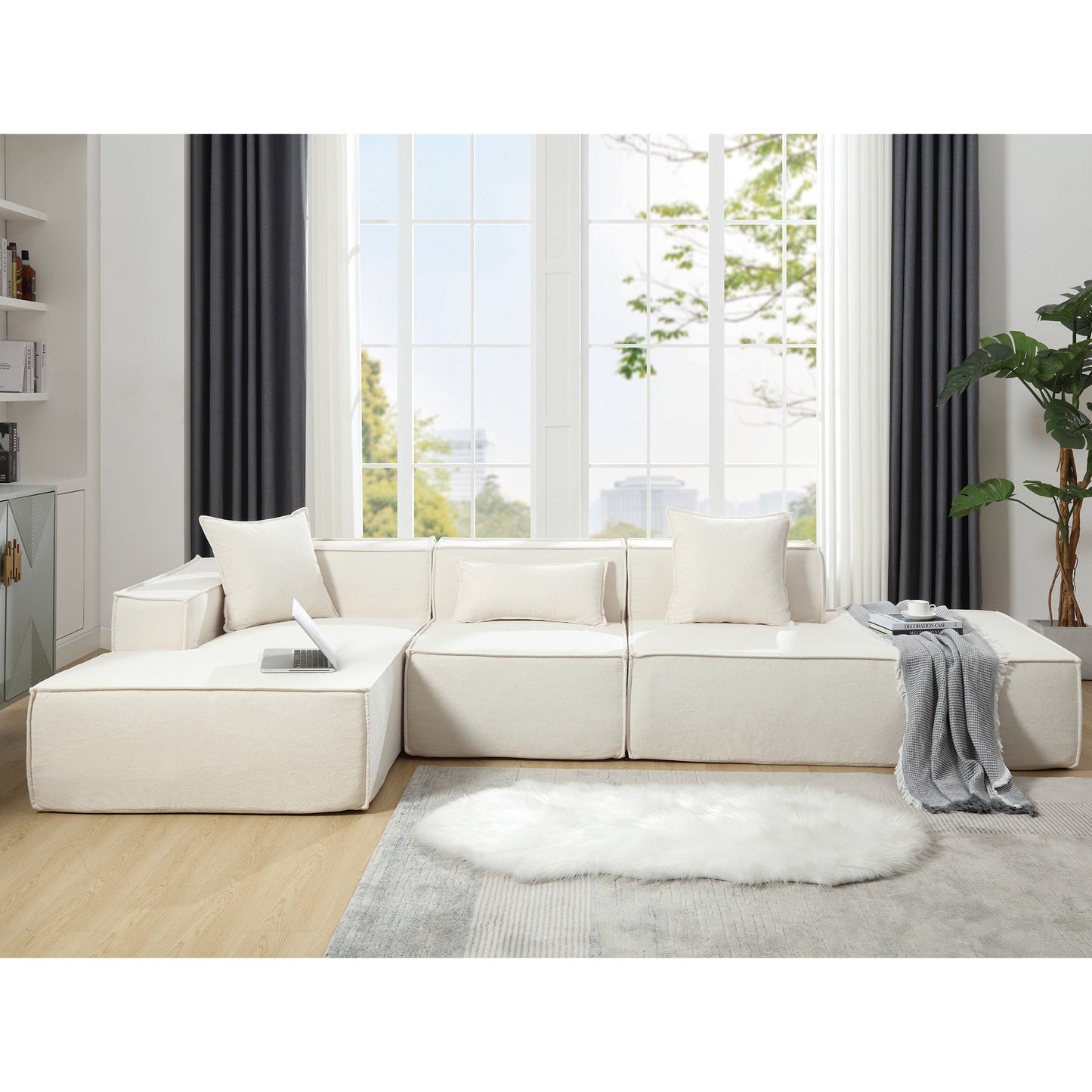 Cream modular sectional sofa with plush cushions and throw blankets Modern living room
