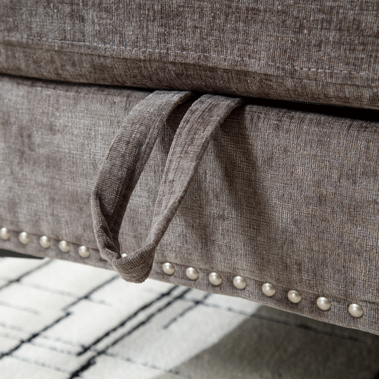 Taupe velvet sofa bed with pullout handle and decorative nailhead trim