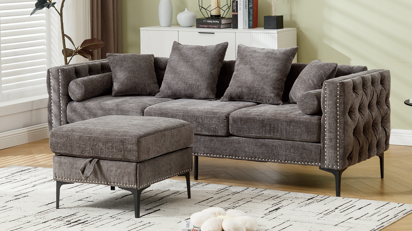 Plush grey velvet sofa with tufted back and silver nailhead trim including matching ottoman