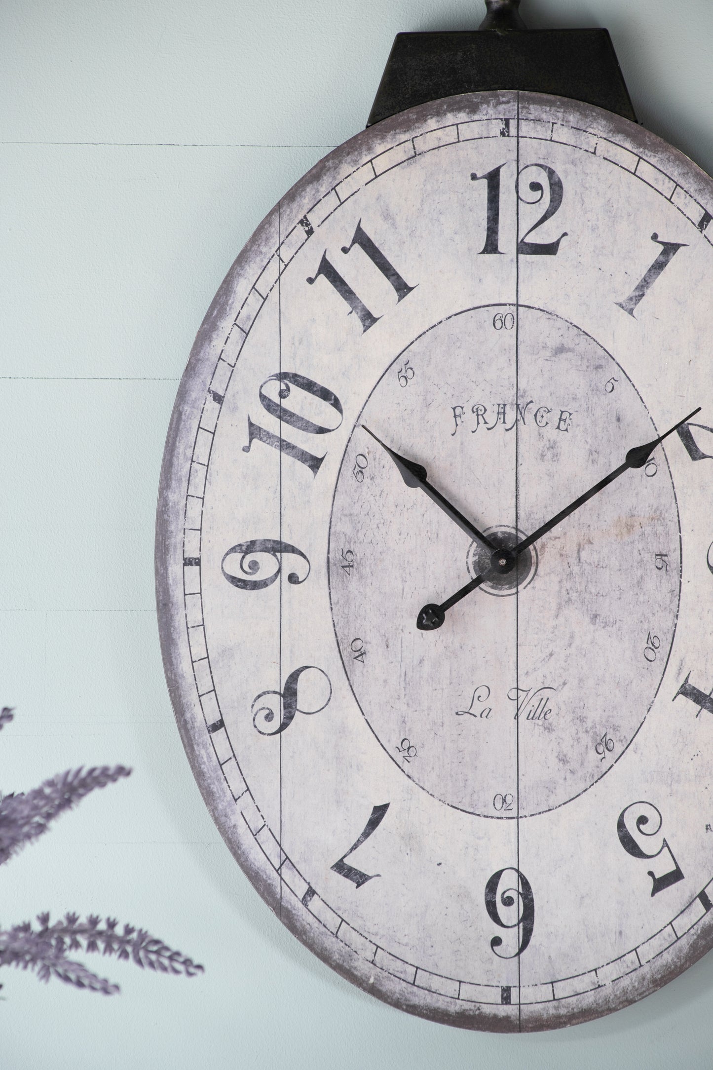 Distressed farmhouse wall clock with vintage Roman numerals and dark metal frame