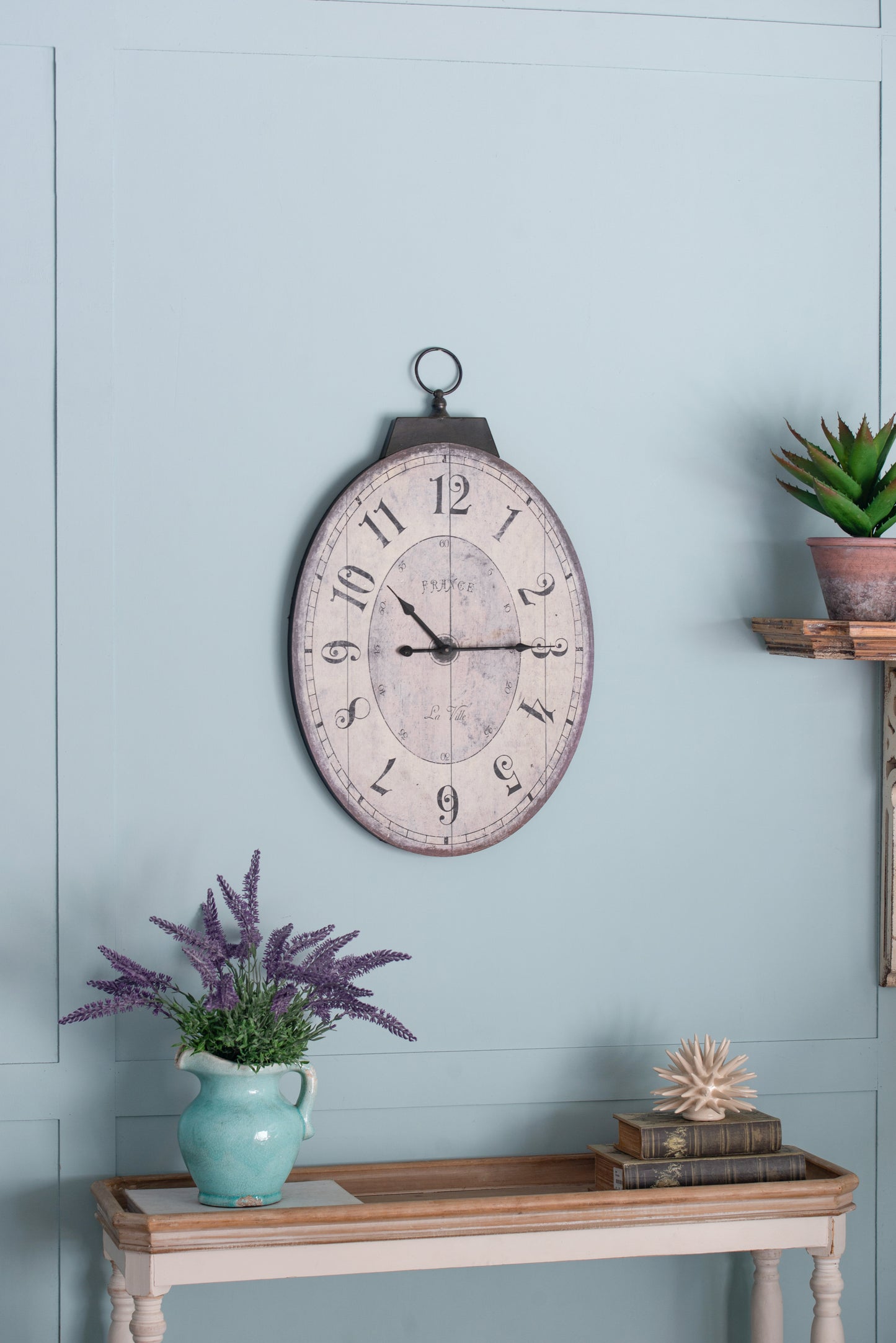 Oval vintage wall clock with distressed finish and French cafestyle numerals