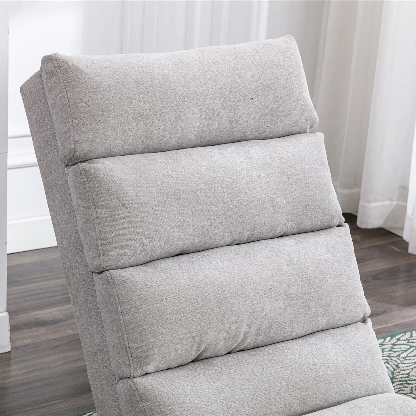 Closeup of a light gray fabric recliner showing its plush cushioning