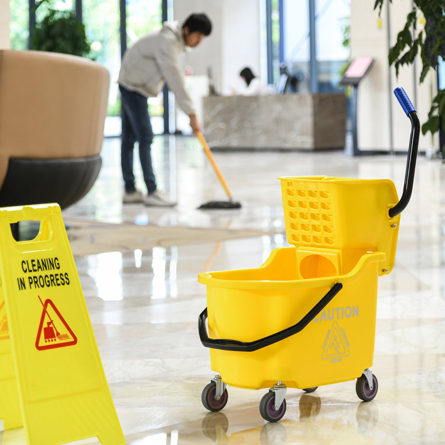 Yellow mop bucket with blue handle and caution sign characters