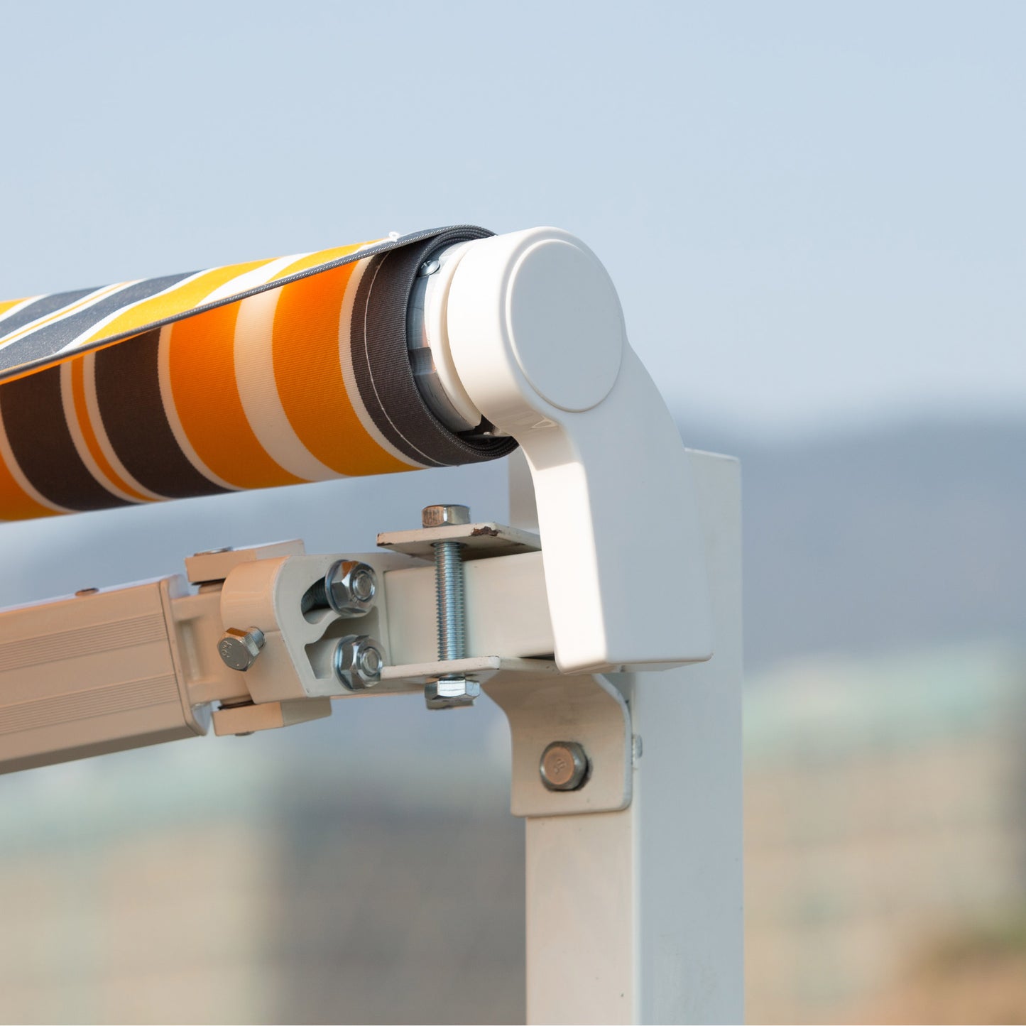 Retractable awning fabric with orange gray and white stripes showing mechanism