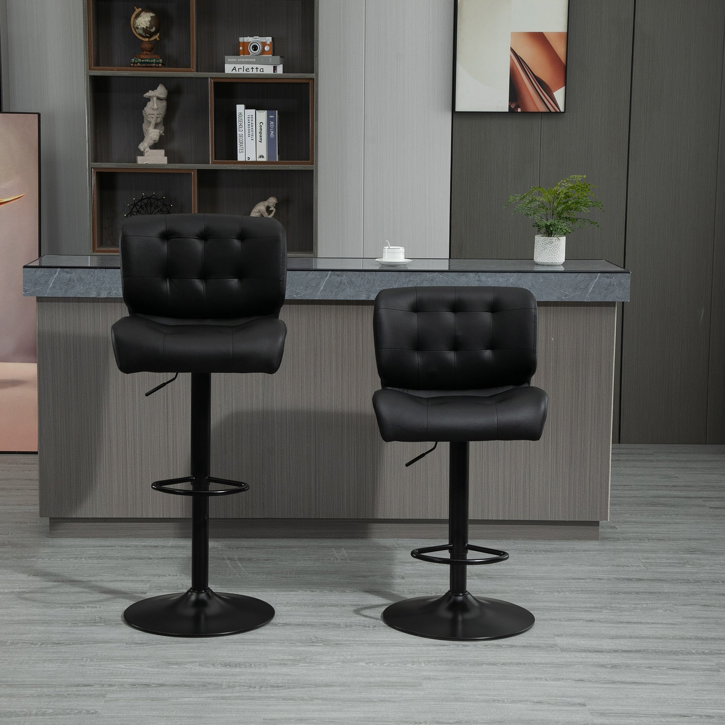 Two black tufted faux leather bar stools with adjustable height and footrest