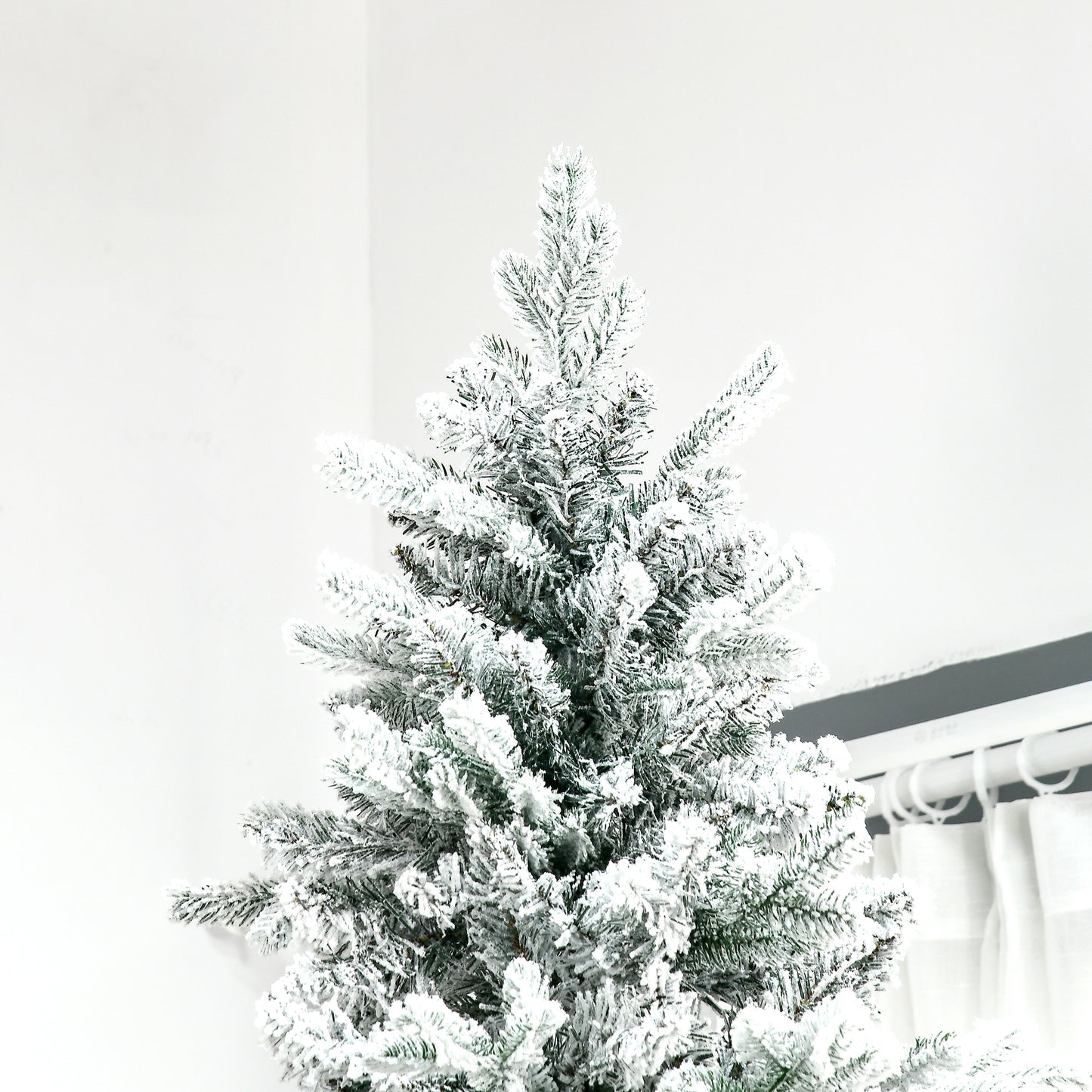 Flocked artificial Christmas tree with dense branches creating a winter wonderland aesthetic