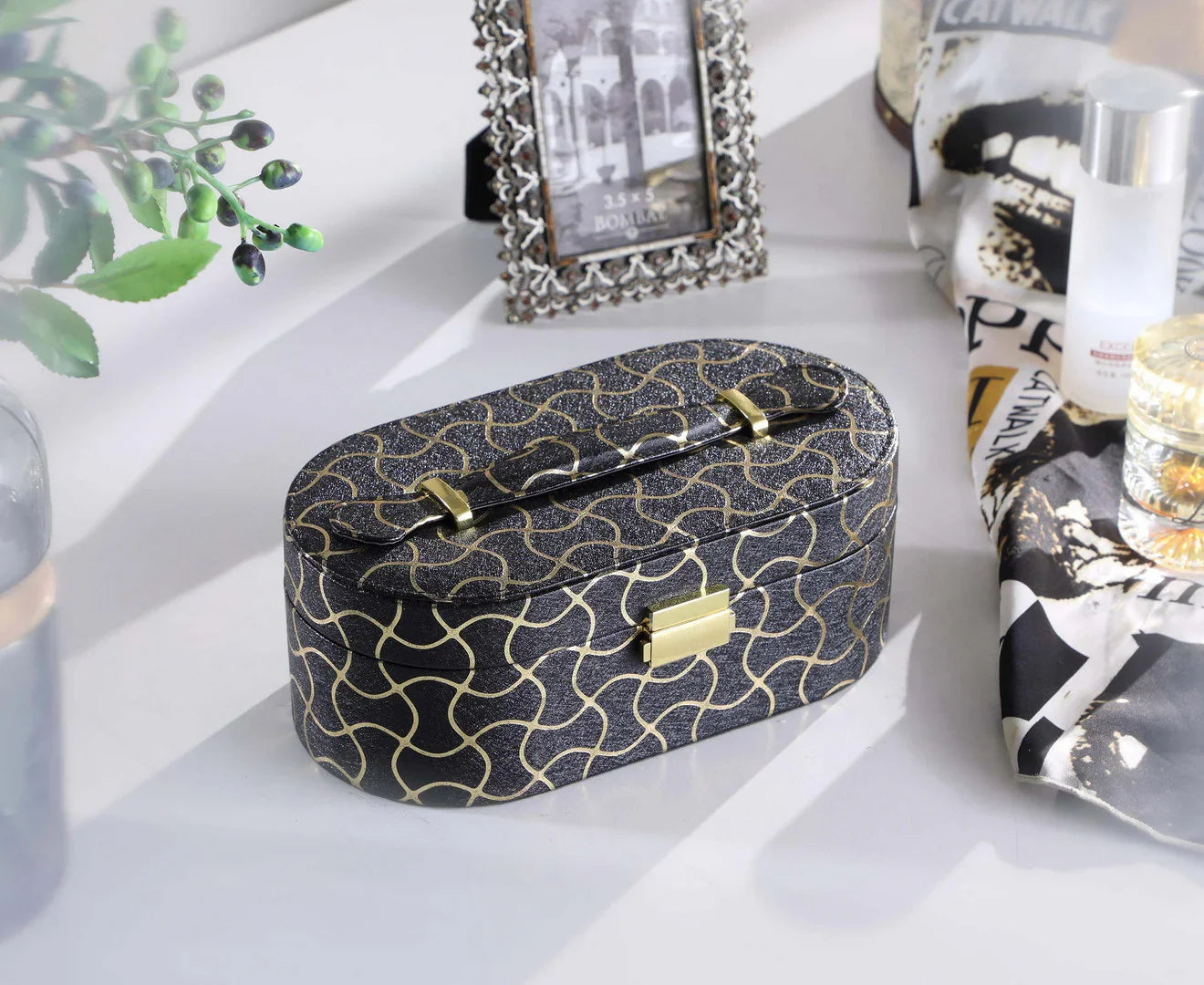 Oval black jewelry box with gold geometric pattern