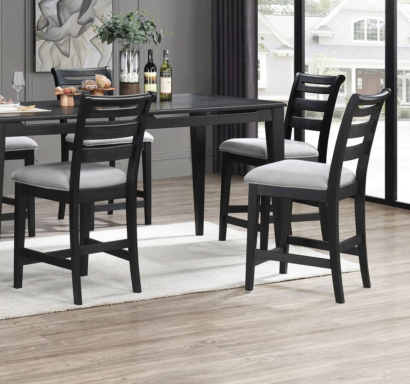 Black wooden counter stools with light gray upholstered seats arranged around a dining table