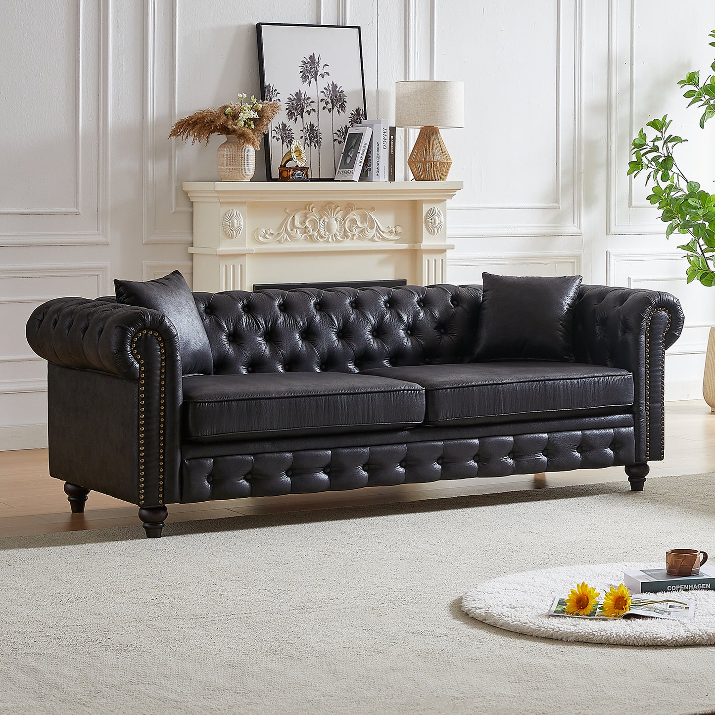 Black leather tufted chesterfield sofa with brass nailhead trim characters
