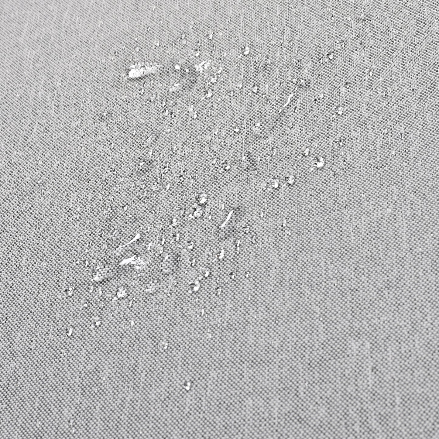 Closeup of water beading on a gray fabric showcasing its waterrepellent quality