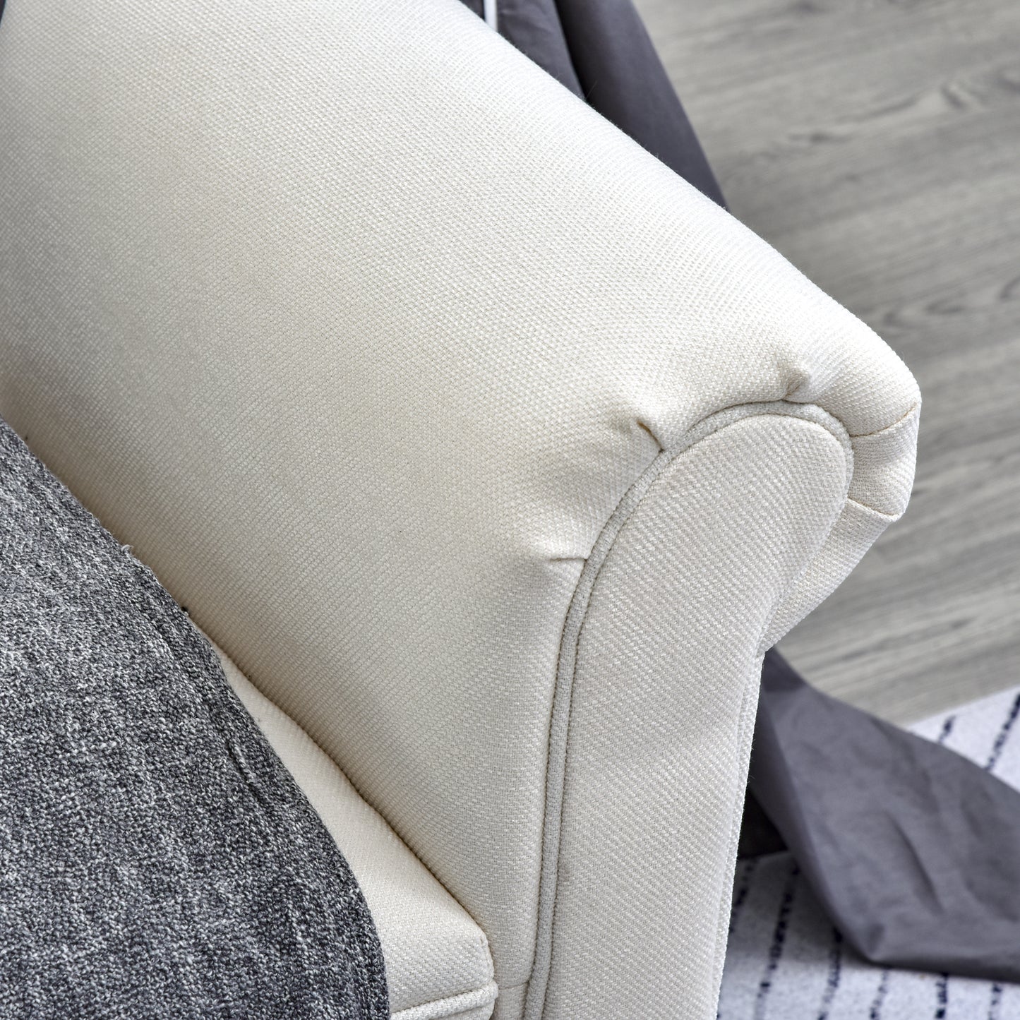 Cream textured fabric armchair armrest with grey throw blanket detail