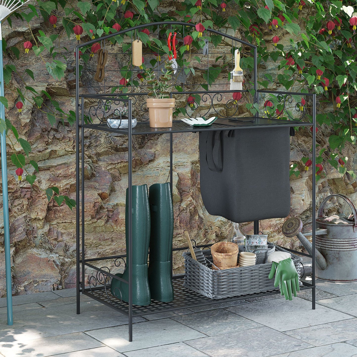 Black metal garden potting bench with pruning shears plant and decorative swirls