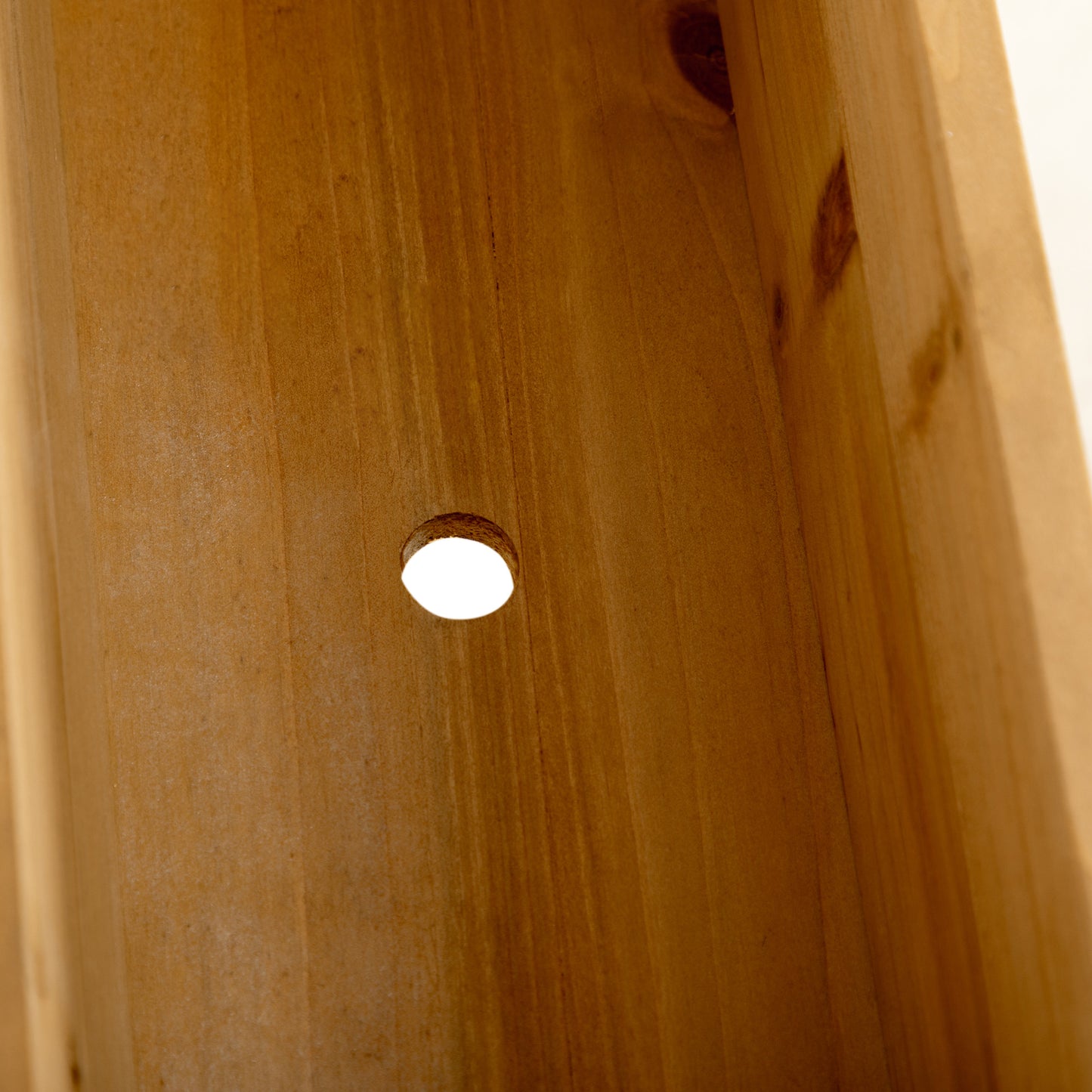 Closeup of natural wood grain with a small circular bore hole