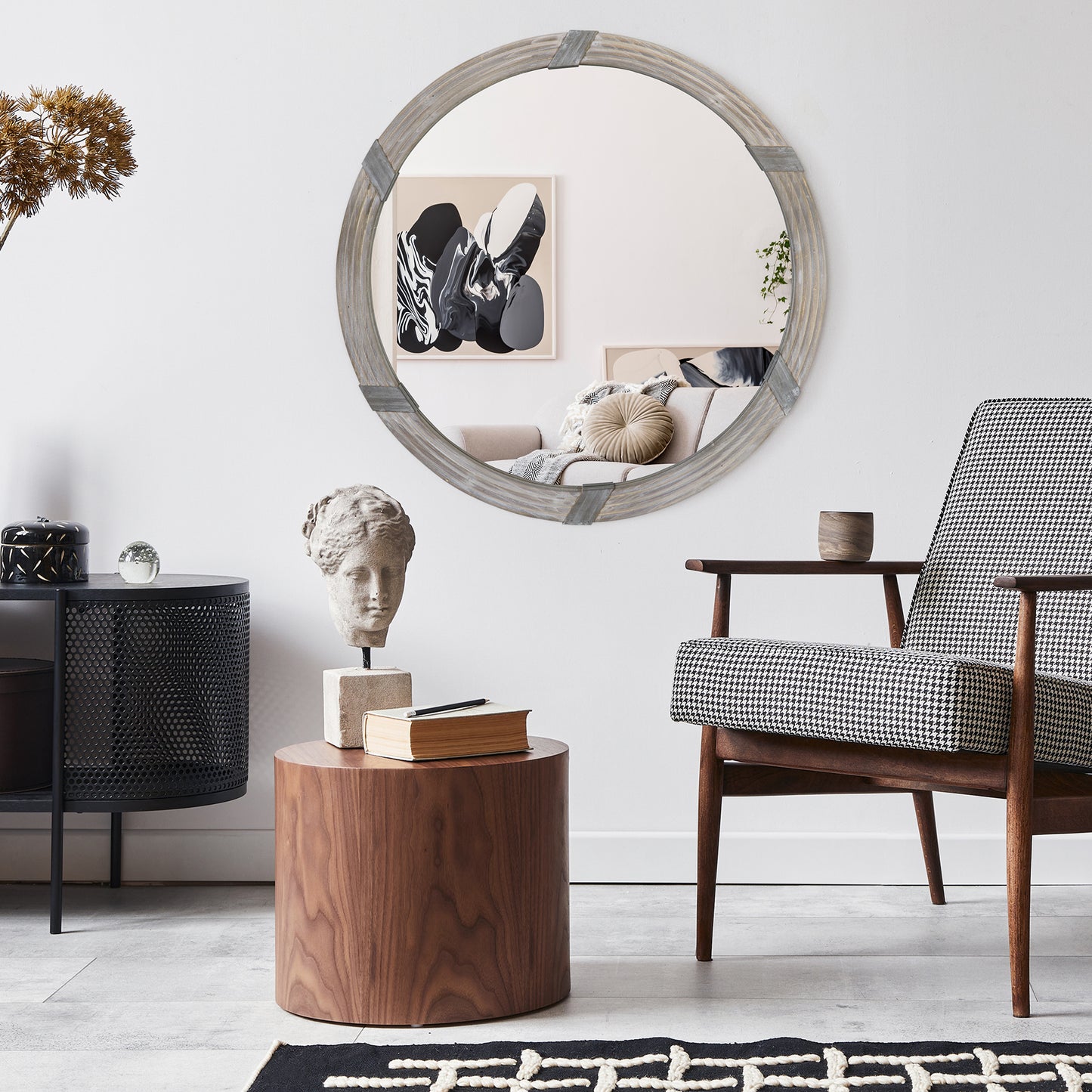 Round grey wood framed mirror with rustic metal accents and textured detailing