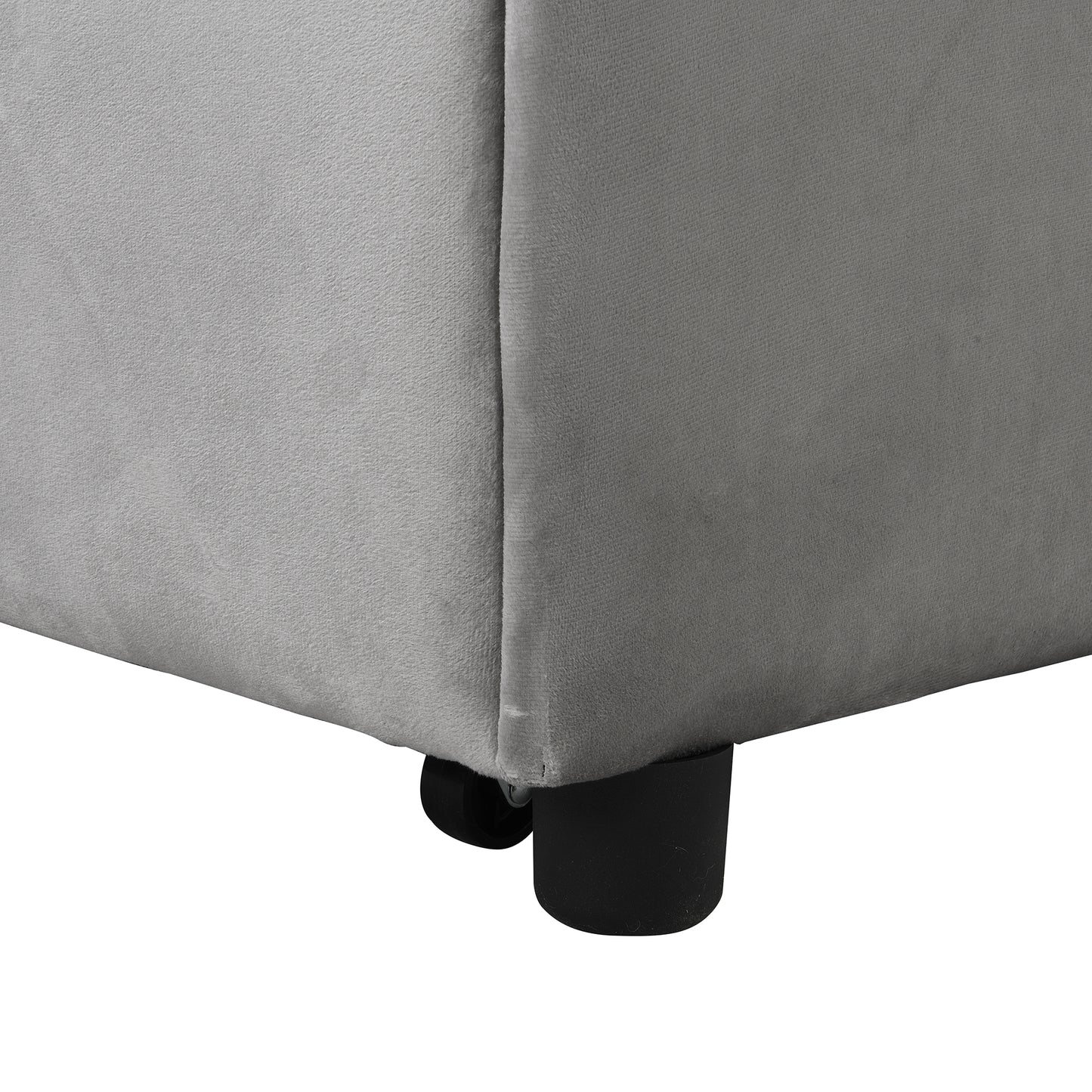 Closeup of a gray velvet storage ottoman corner with black cylindrical feet on a white background