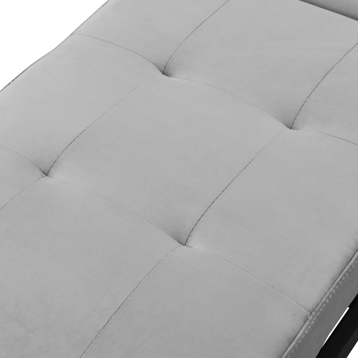 Closeup of a grey tufted fabric chaise lounge with button detailing