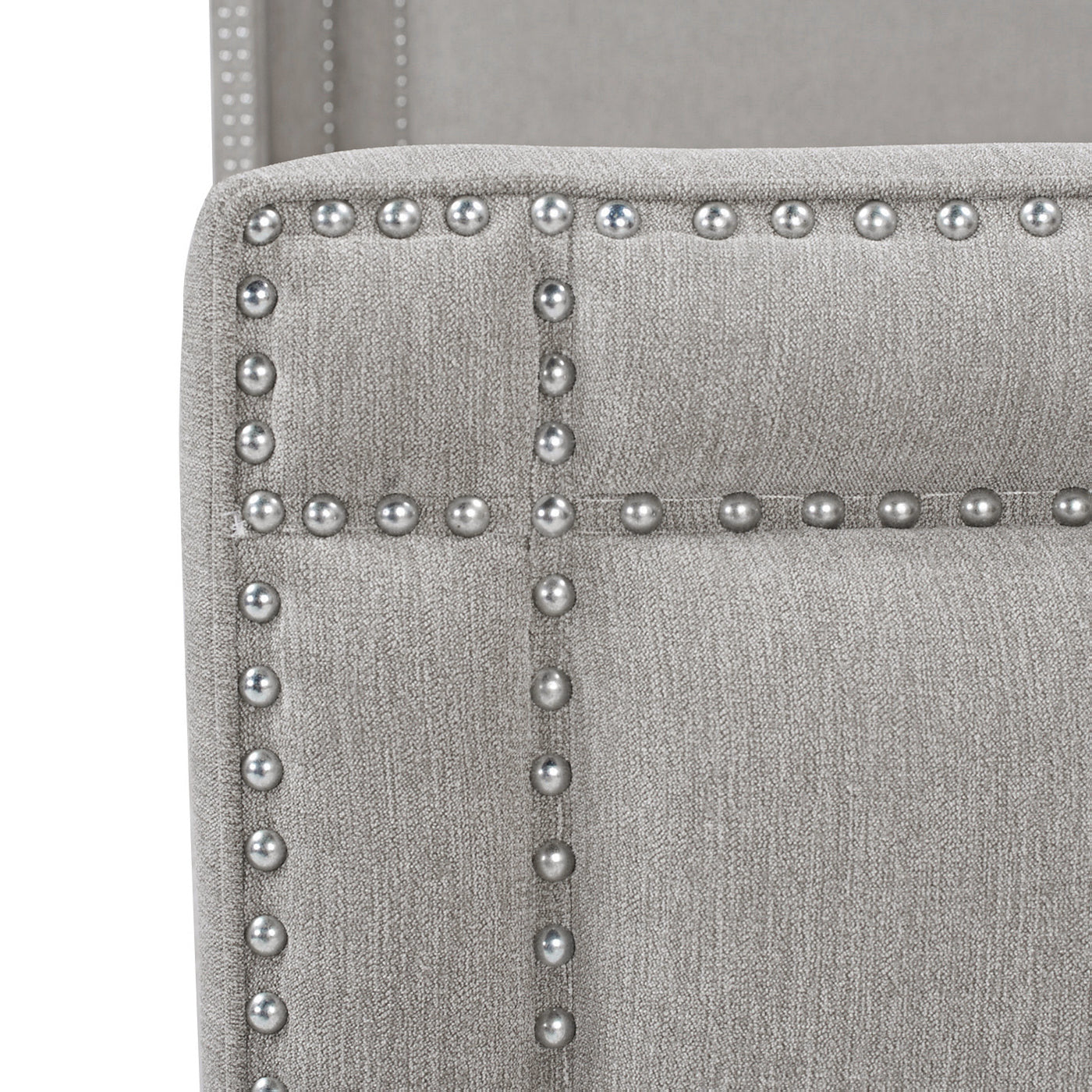 Light gray upholstered chair detail with decorative nailhead trim