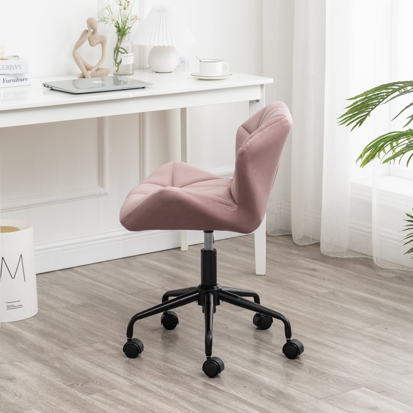 Upholstered pink office chair with tufted diamond pattern and black swivel base