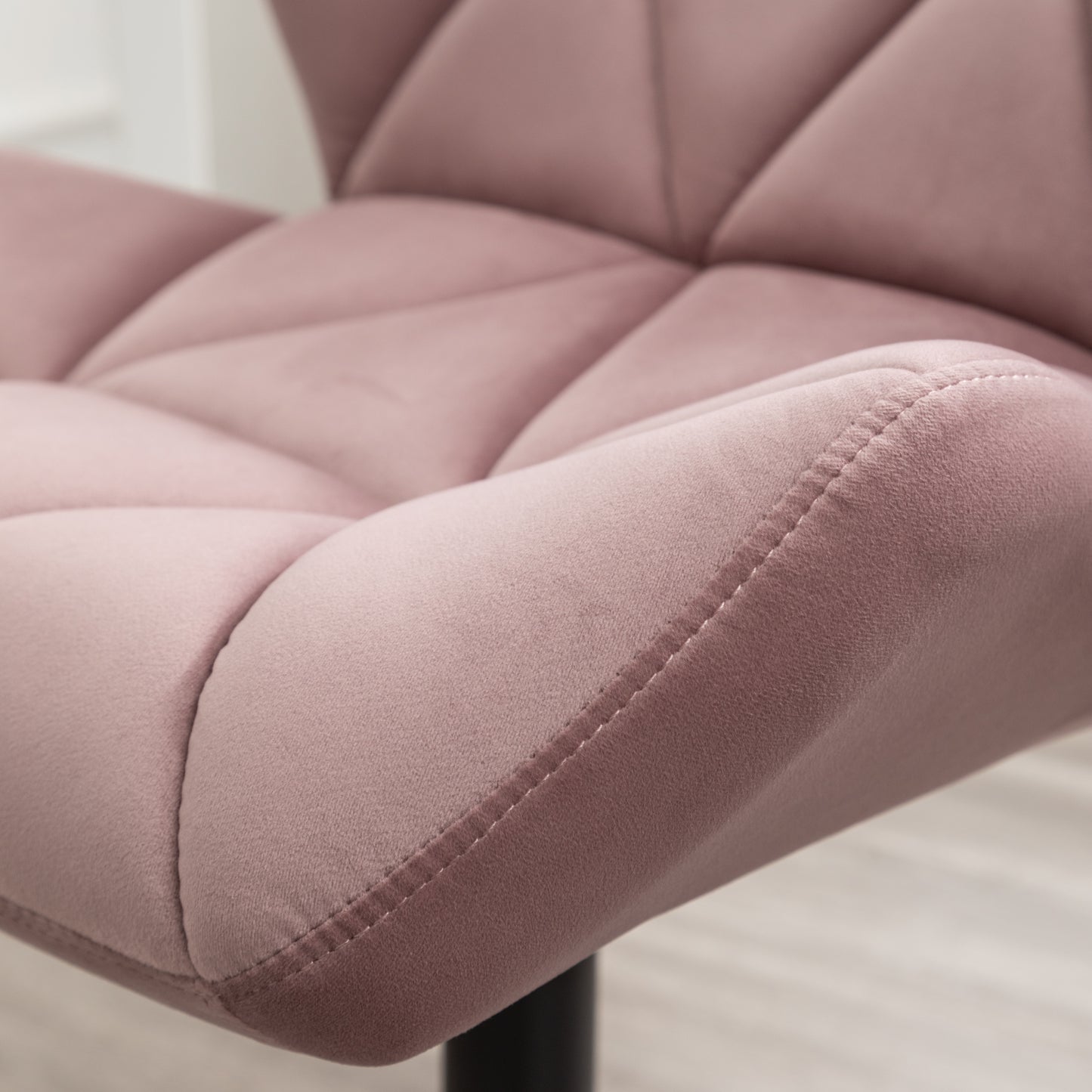 Close up of a plush rose velvet armchair with diamond tufting
