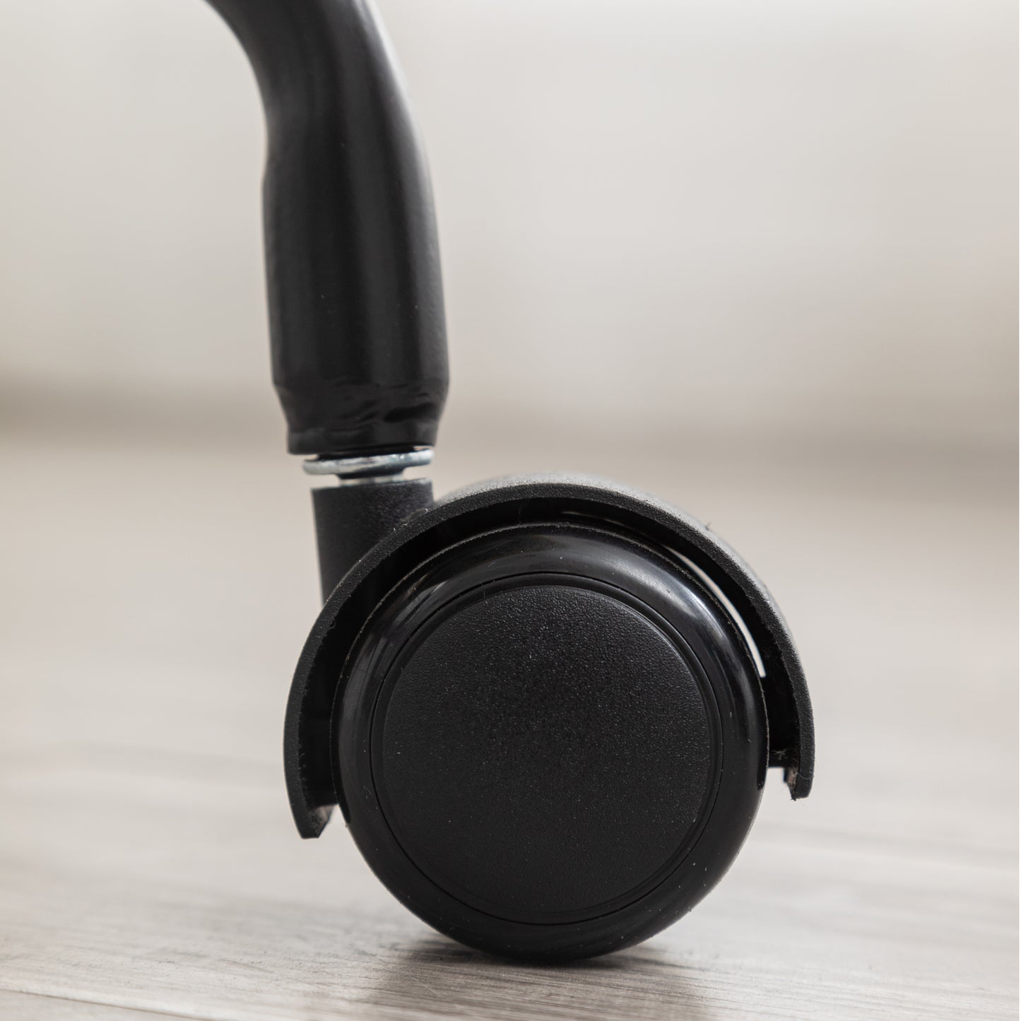 Black office chair caster wheel with textured surface for smooth movement on floors