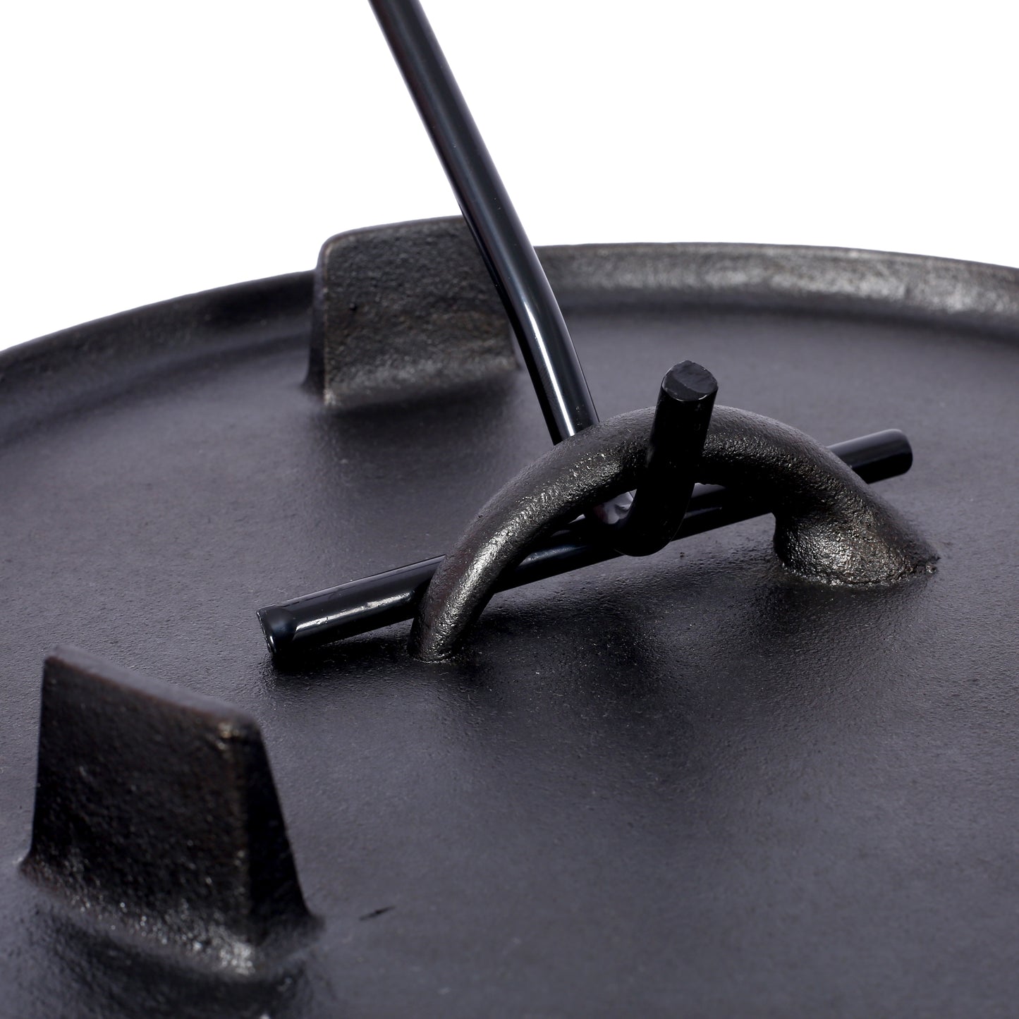 Closeup of a black cast iron Dutch oven lid with a black metal handle hook