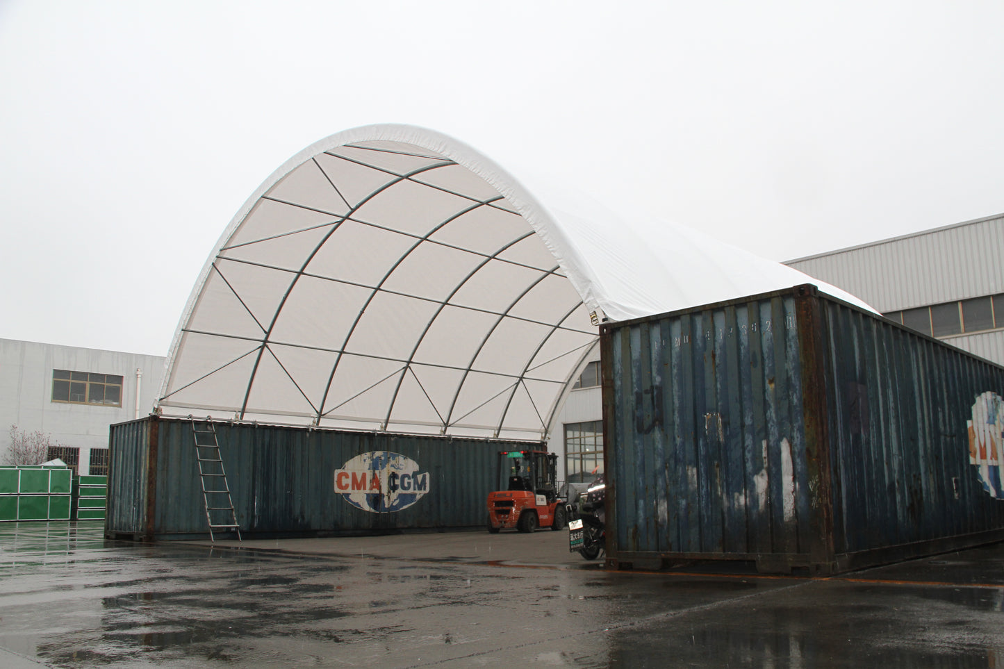 Large arched fabric structure supported by shipping containers a temporary warehouse solution