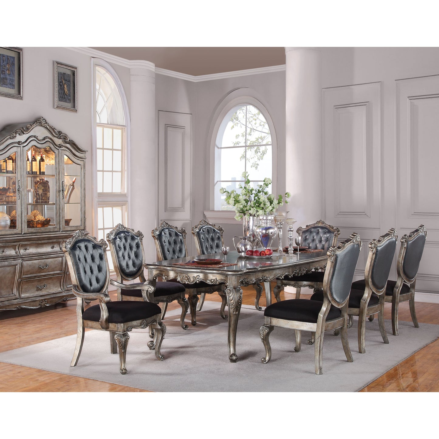Ornate silverfinish dining table with plush velvet chairs featuring tufted backs