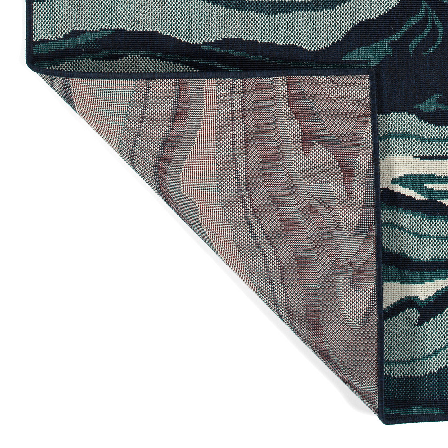 Closeup of a dark blue area rug with a detailed woven pattern in green and white abstract shapes