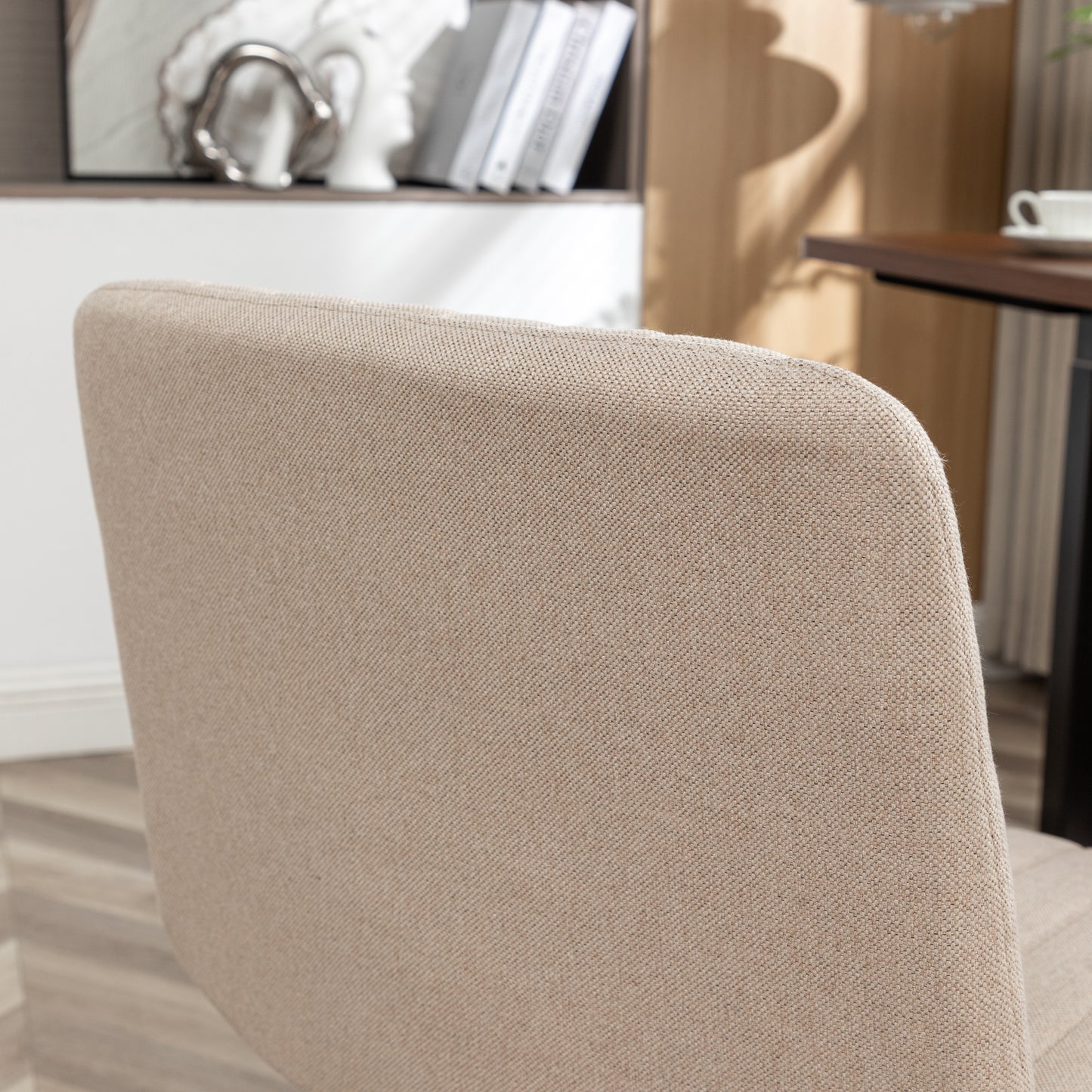 Closeup of a textured beige fabric chair back with subtle stitching detail