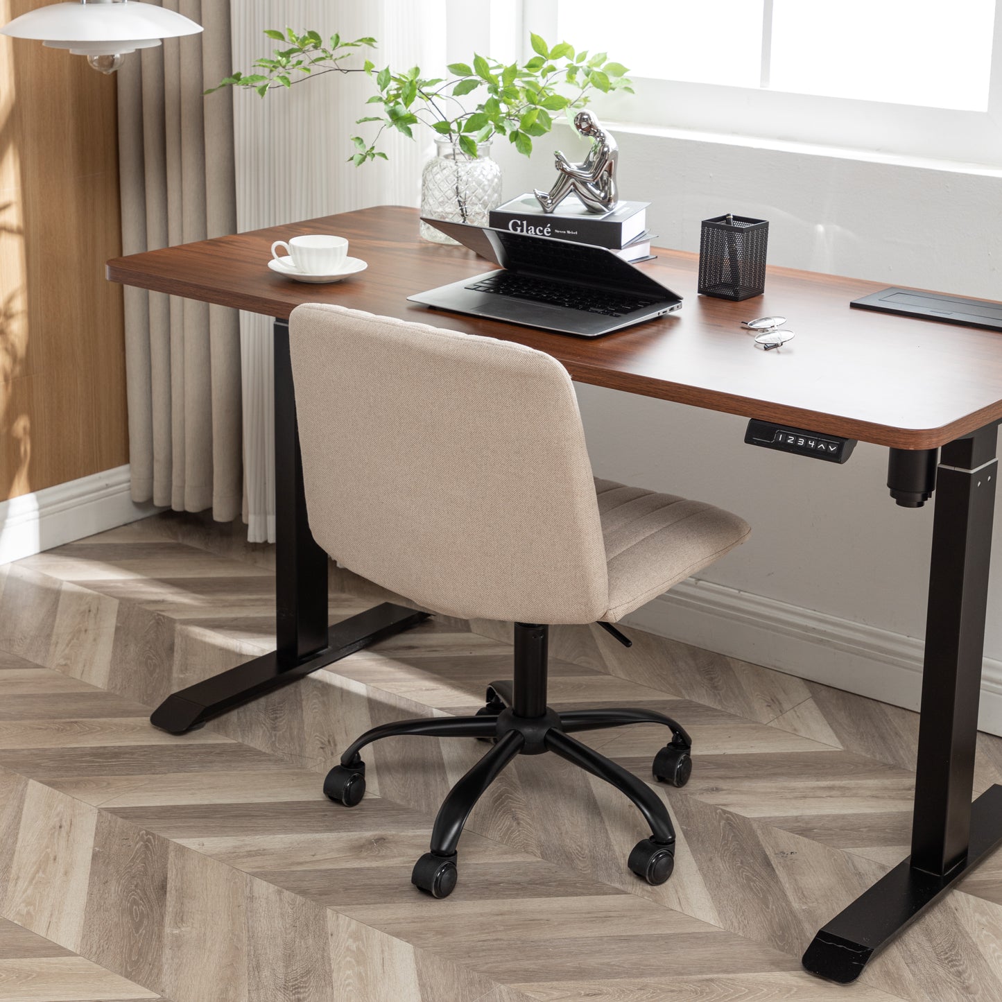 Beige upholstered office chair with black casters on a woodgrain floor