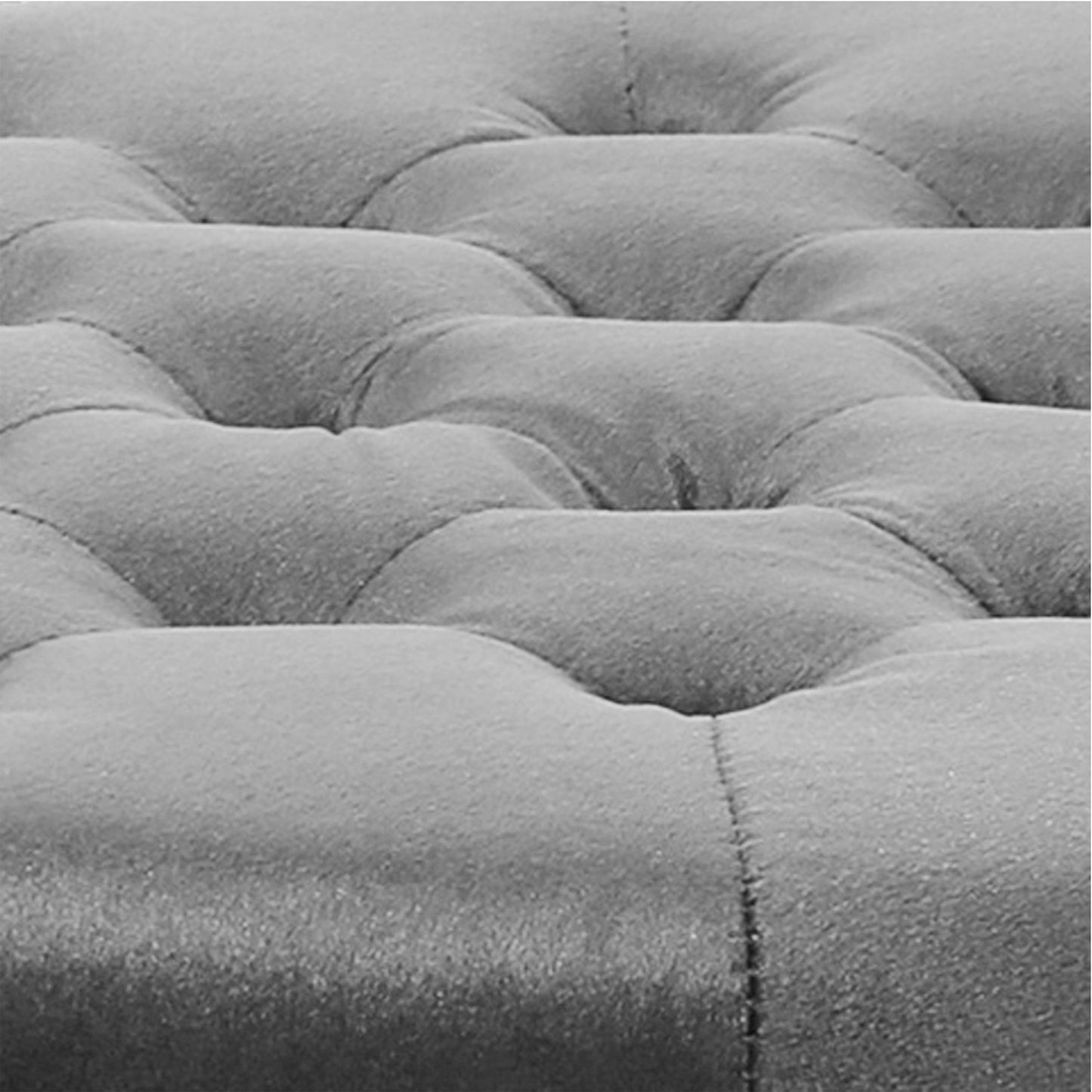Closeup of grey tufted velvet upholstery fabric on a sofa cushion offering a luxurious texture