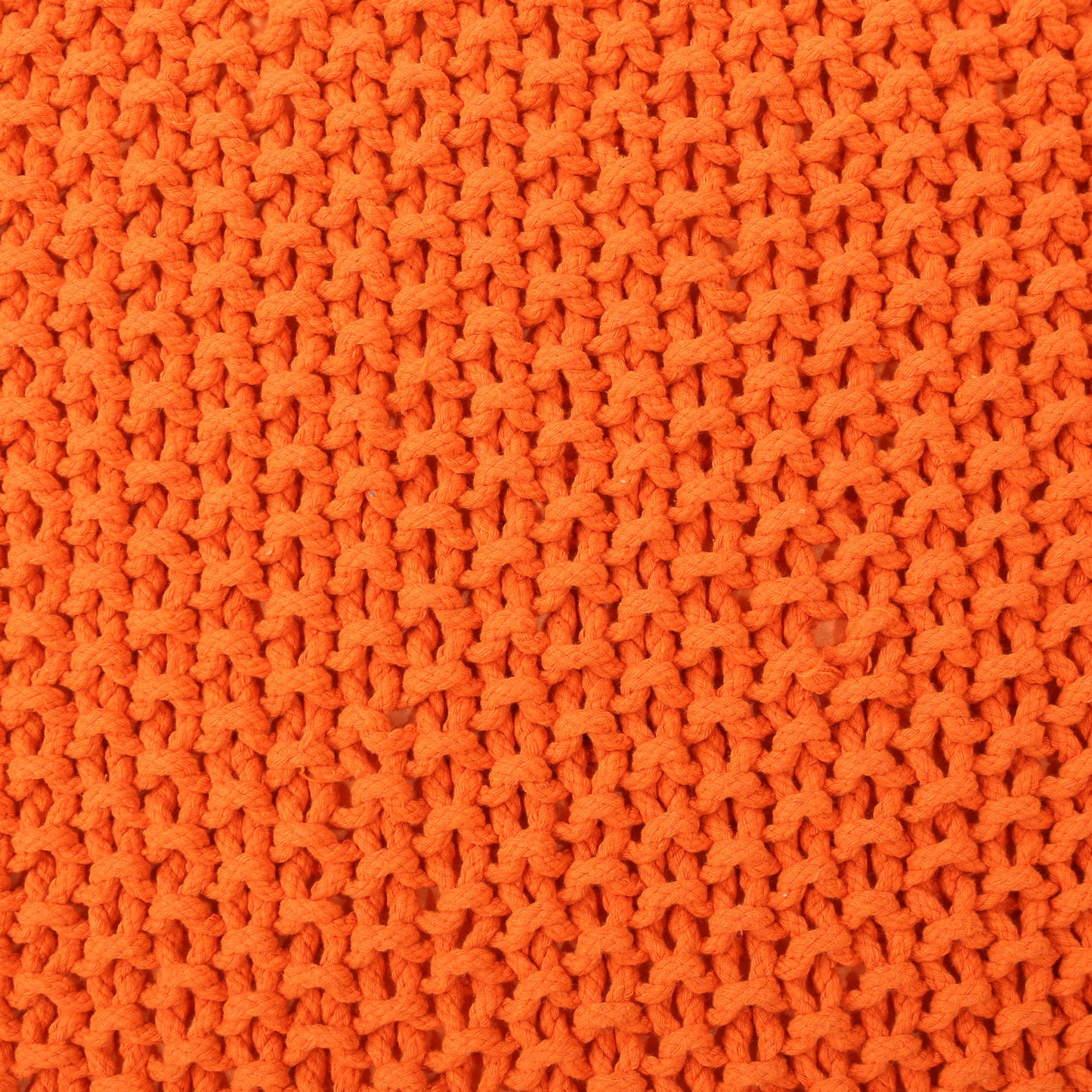 Closeup of bright orange chunky knit fabric showcasing textured yarn loops