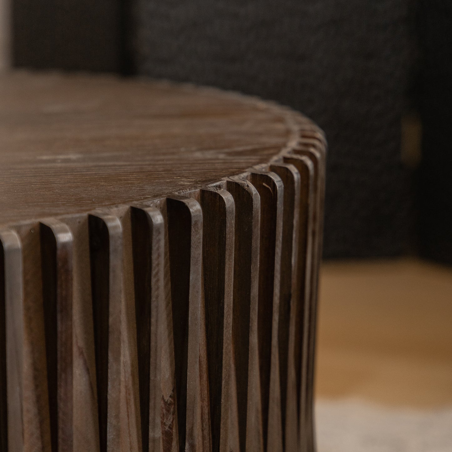 Dark brown wooden side table with fluted texture and textured top surface