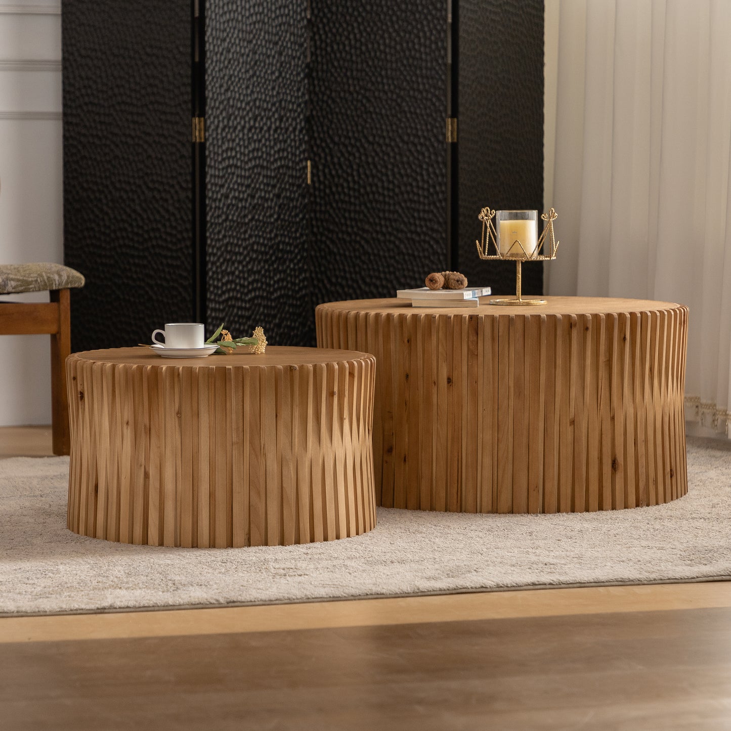Round wood coffee table with textured vertical slats and a gold candle holder
