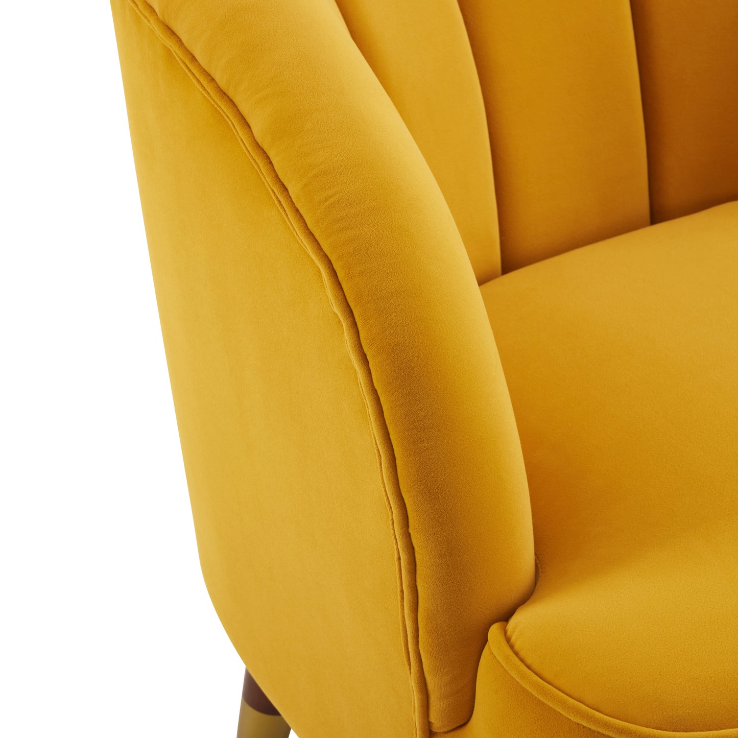 Closeup of a plush gold velvet armchair with channel tufting and piped seams