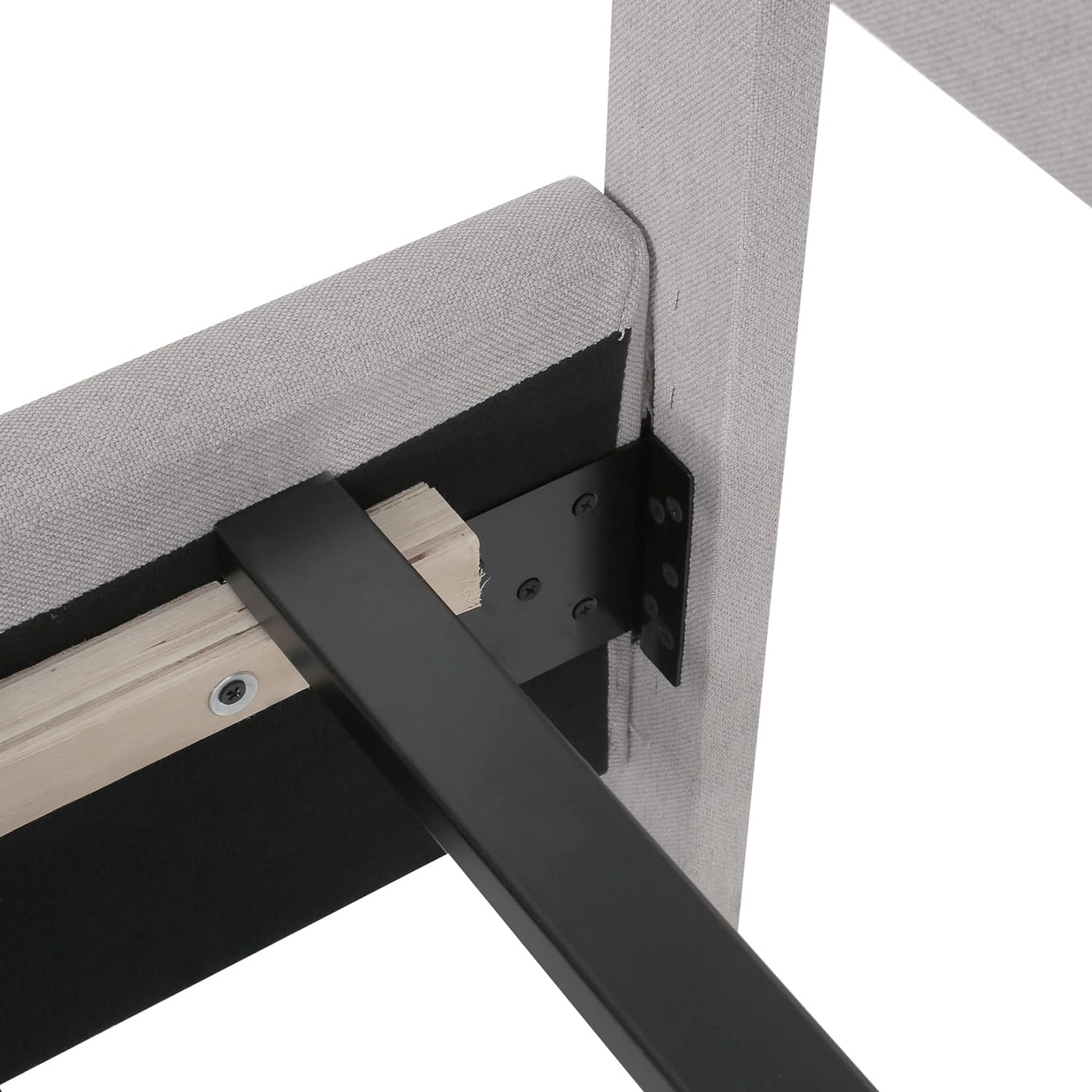 Closeup of upholstered grey bed frame corner with black metal support bracket