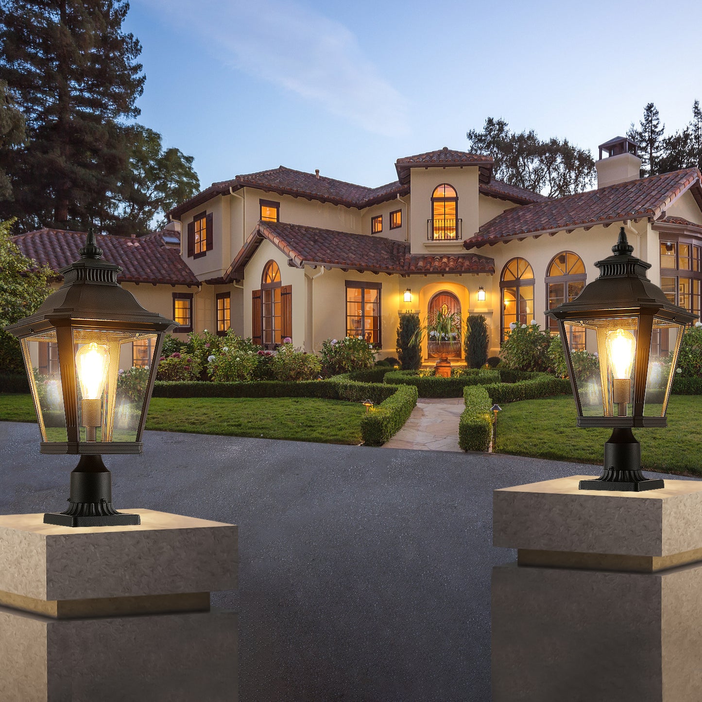 Black metal post lantern with glass panes illuminating a driveway at dusk