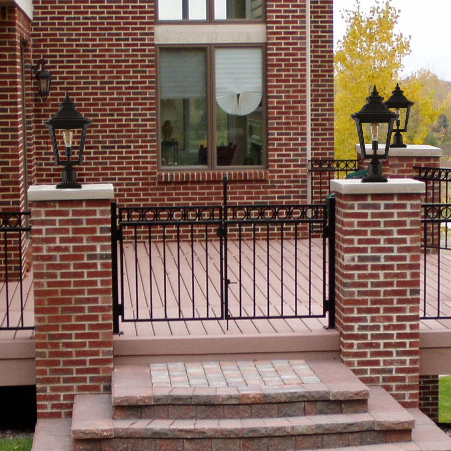 Black colonial style post lantern with clear glass panels illuminating a porch entrance